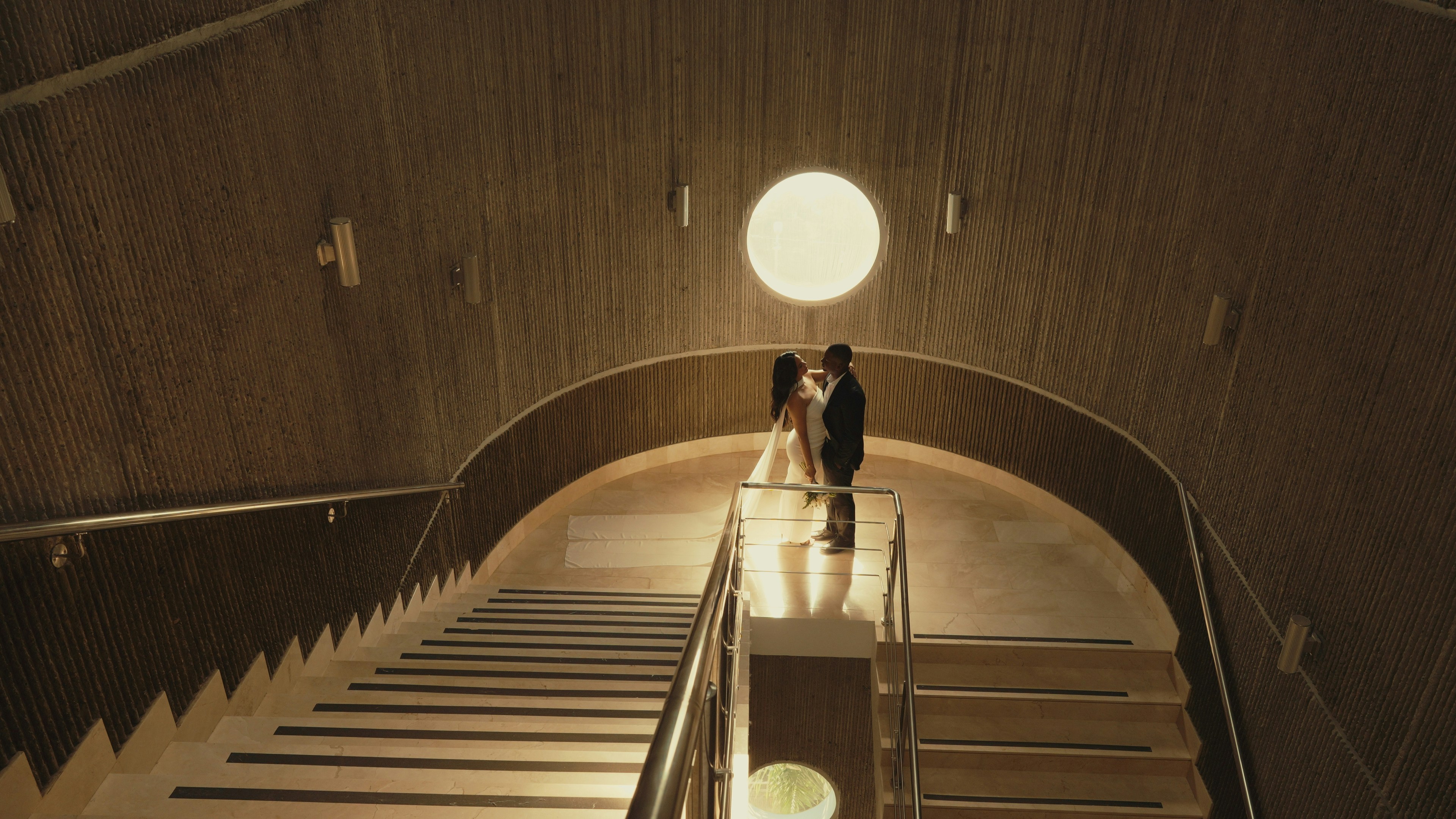 Couple embracing at the top of a modern staircase