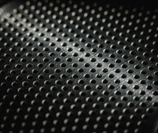 Close-up of a textured metal surface with many small holes.