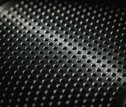 Close-up of a textured metal surface with many small holes.