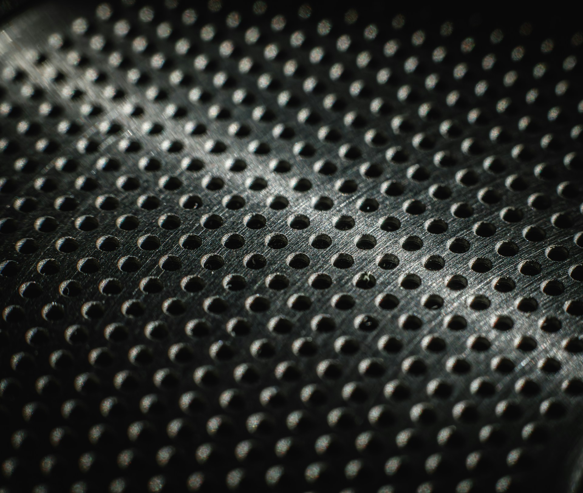 Close-up of a textured metal surface with many small holes.
