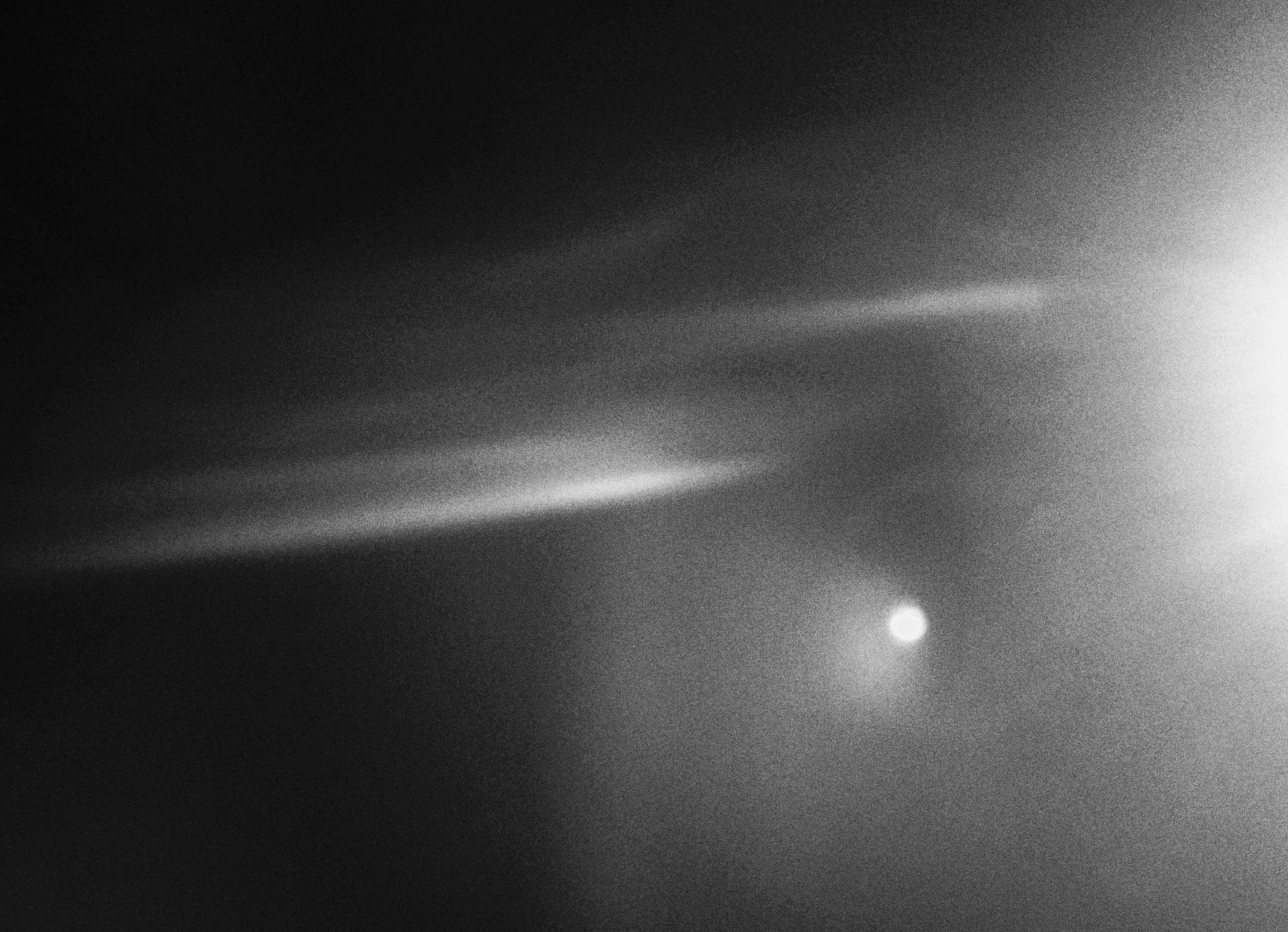 Bright light streaking across dark, misty background