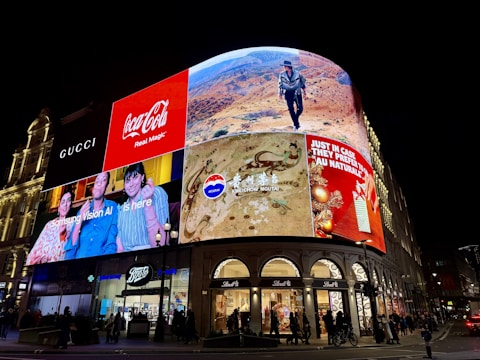 Brightly lit billboards on a building at night.