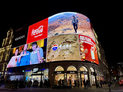 Brightly lit billboards on a building at night.