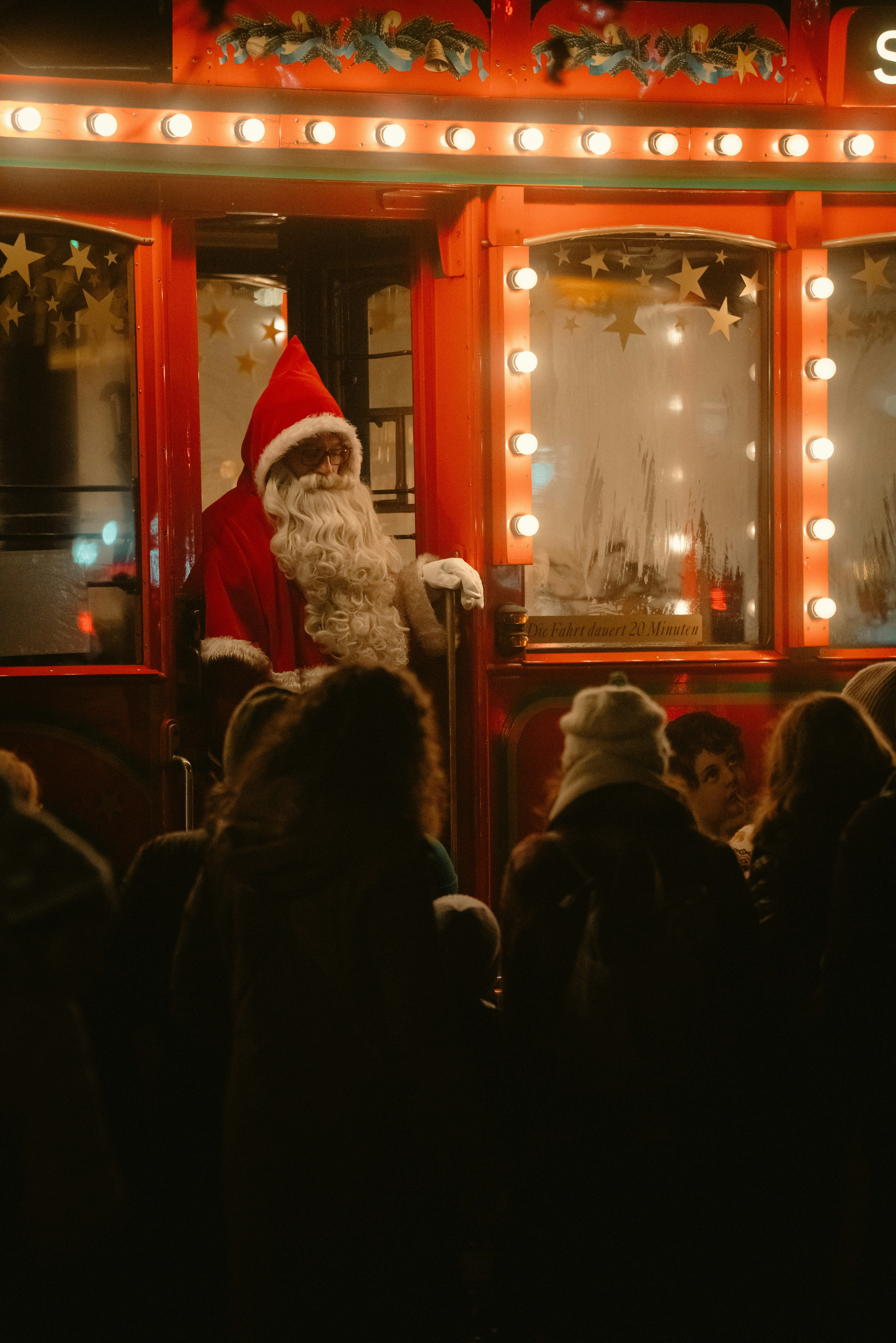 Santa claus greeting people from a decorated carriage