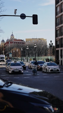 Taxis and cars on a city street during the day.