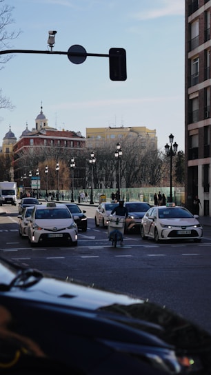Taxis and cars on a city street during the day.