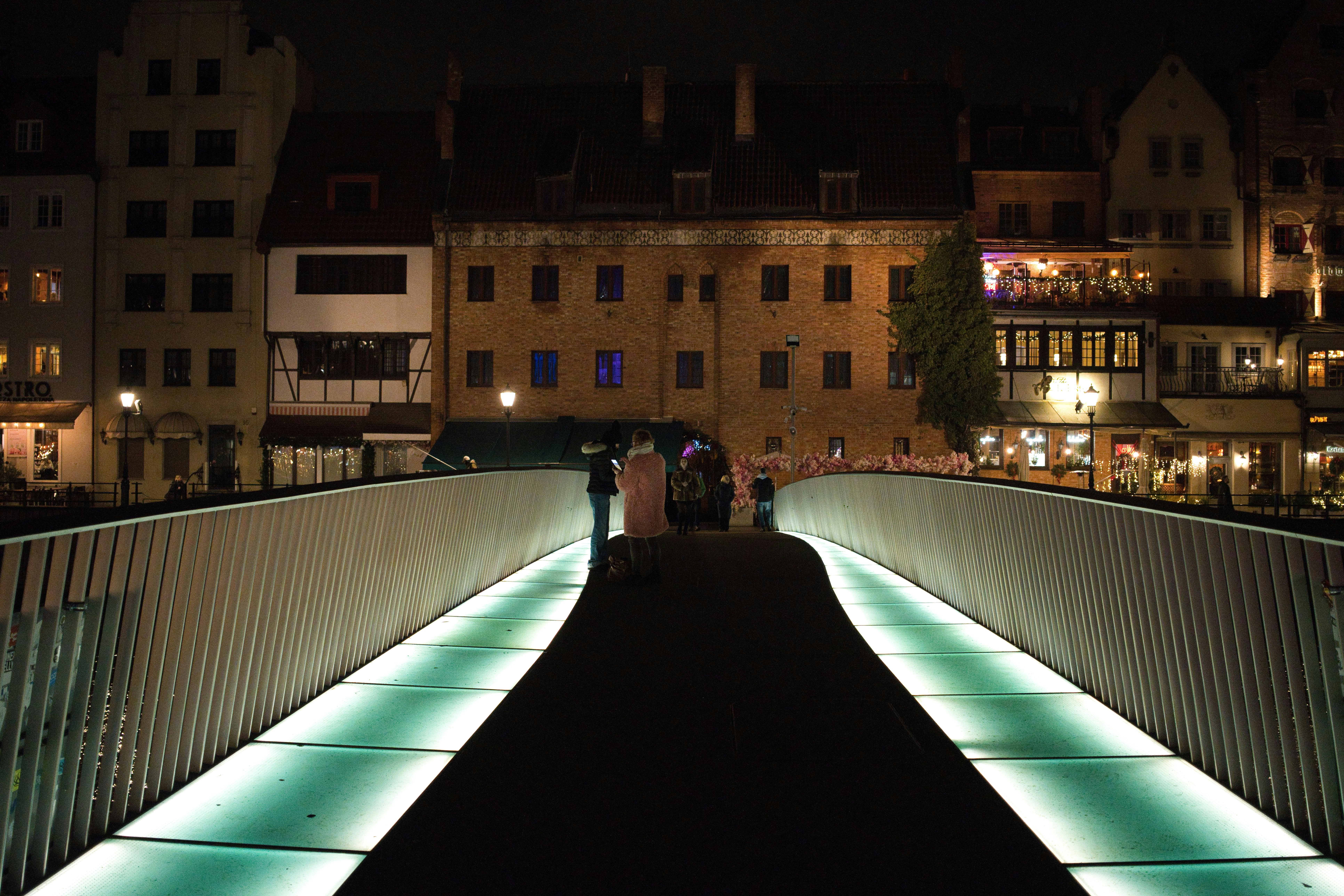 Illuminated bridge at night with buildings in background