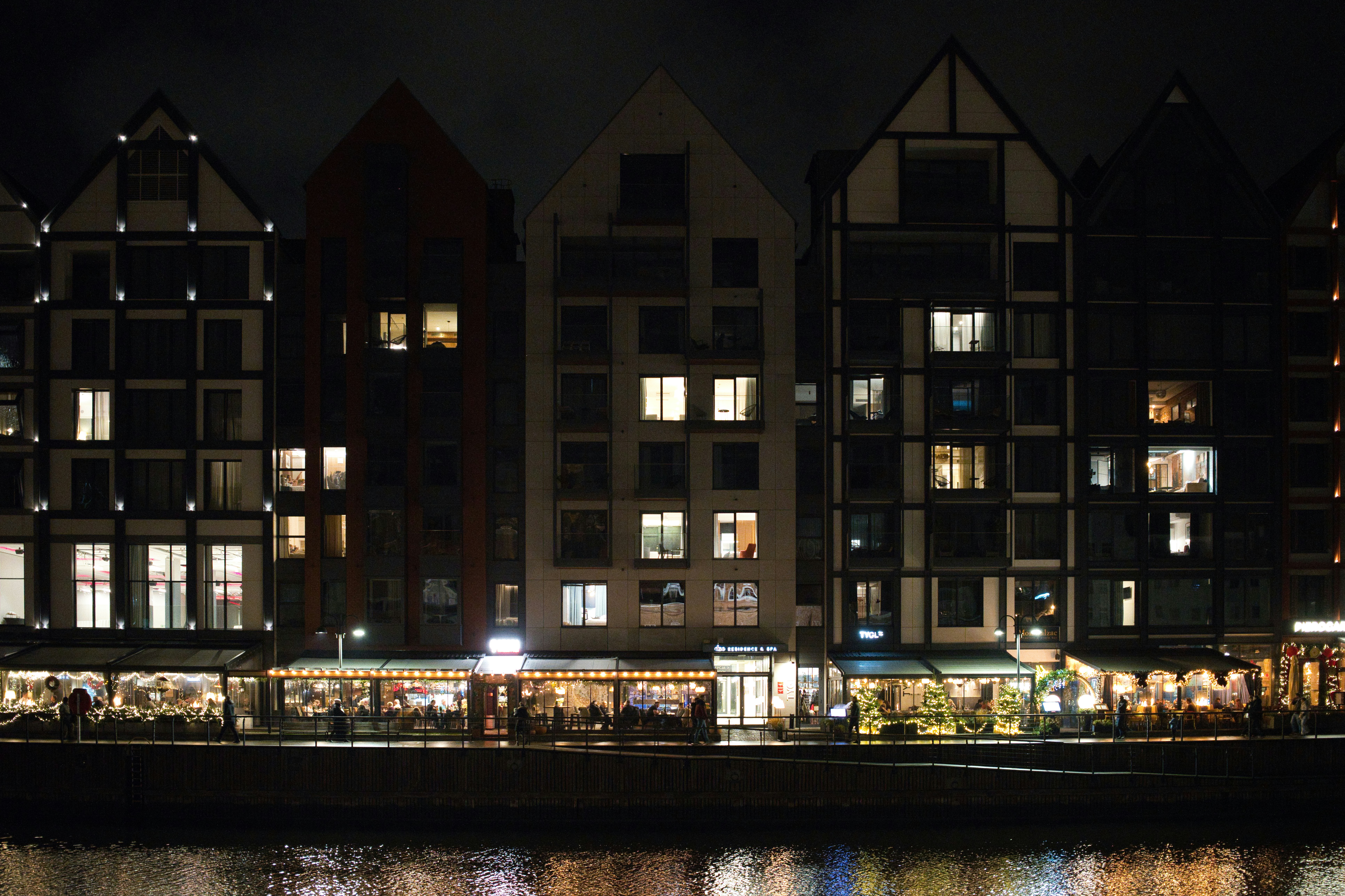 Row of illuminated buildings at night by water