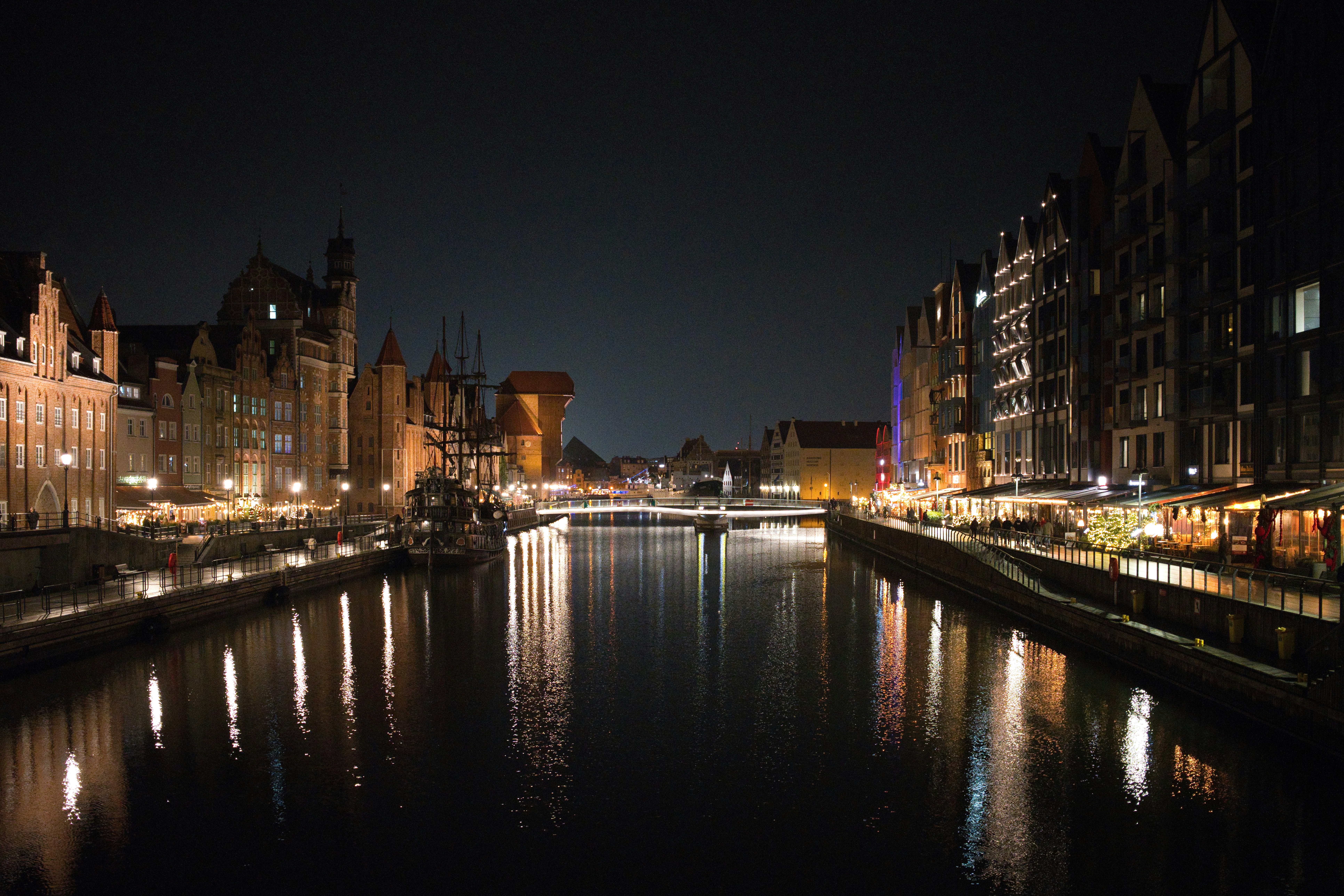 City canal at night with illuminated buildings reflected.