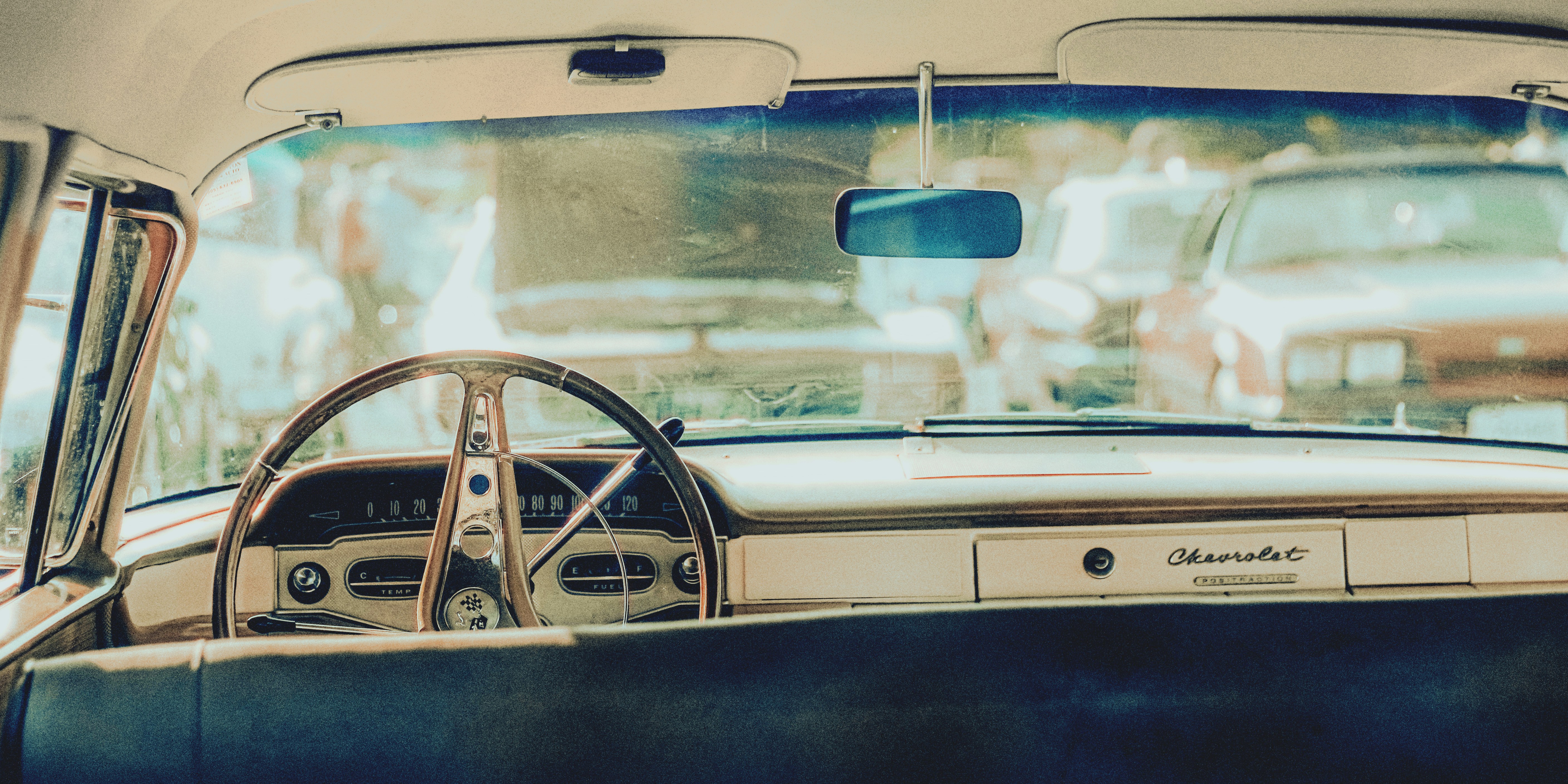 Interior view of a classic car dashboard and steering wheel.