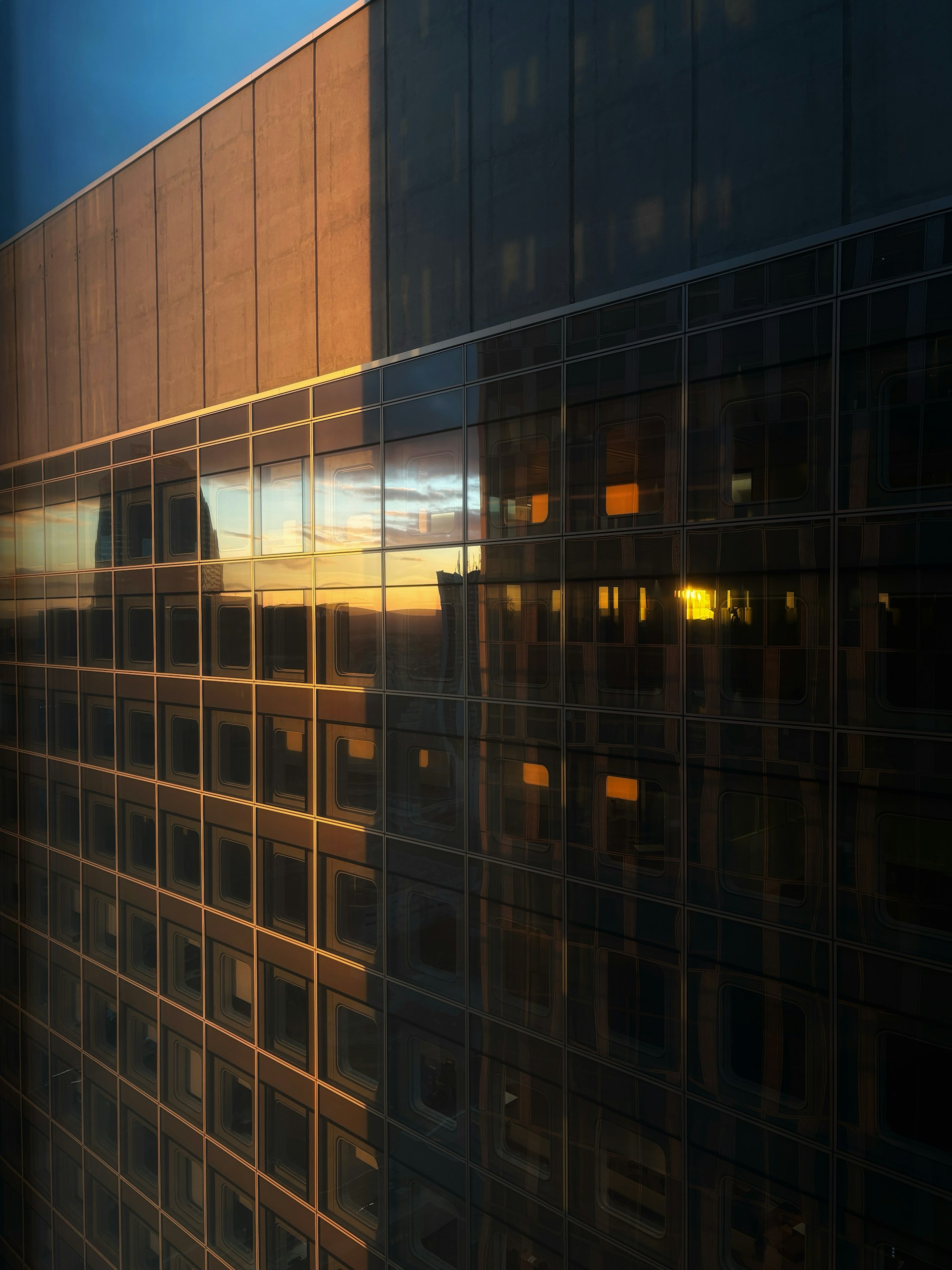 Modern building facade reflecting sunset light.