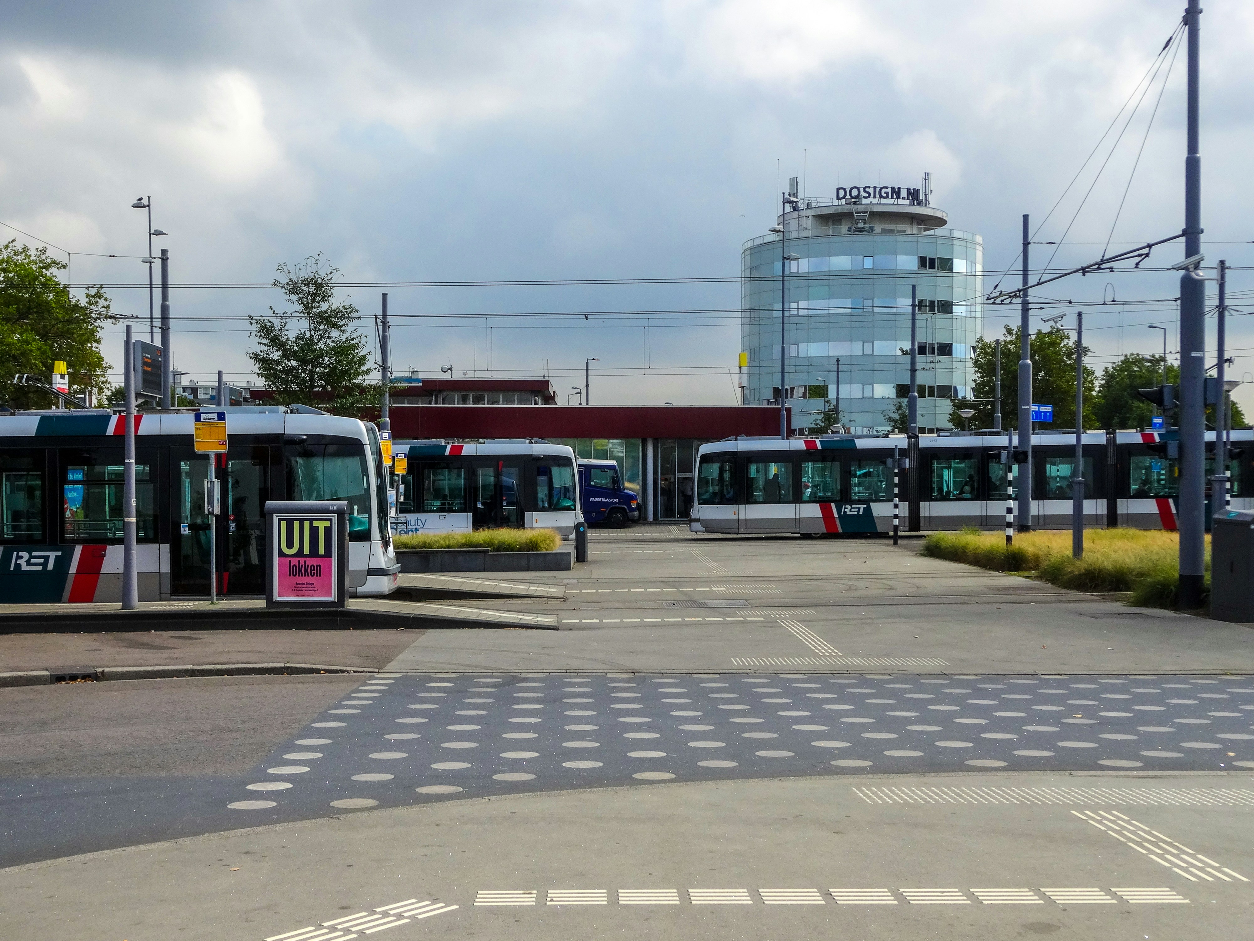 Trams at a modern transit station with glass building.