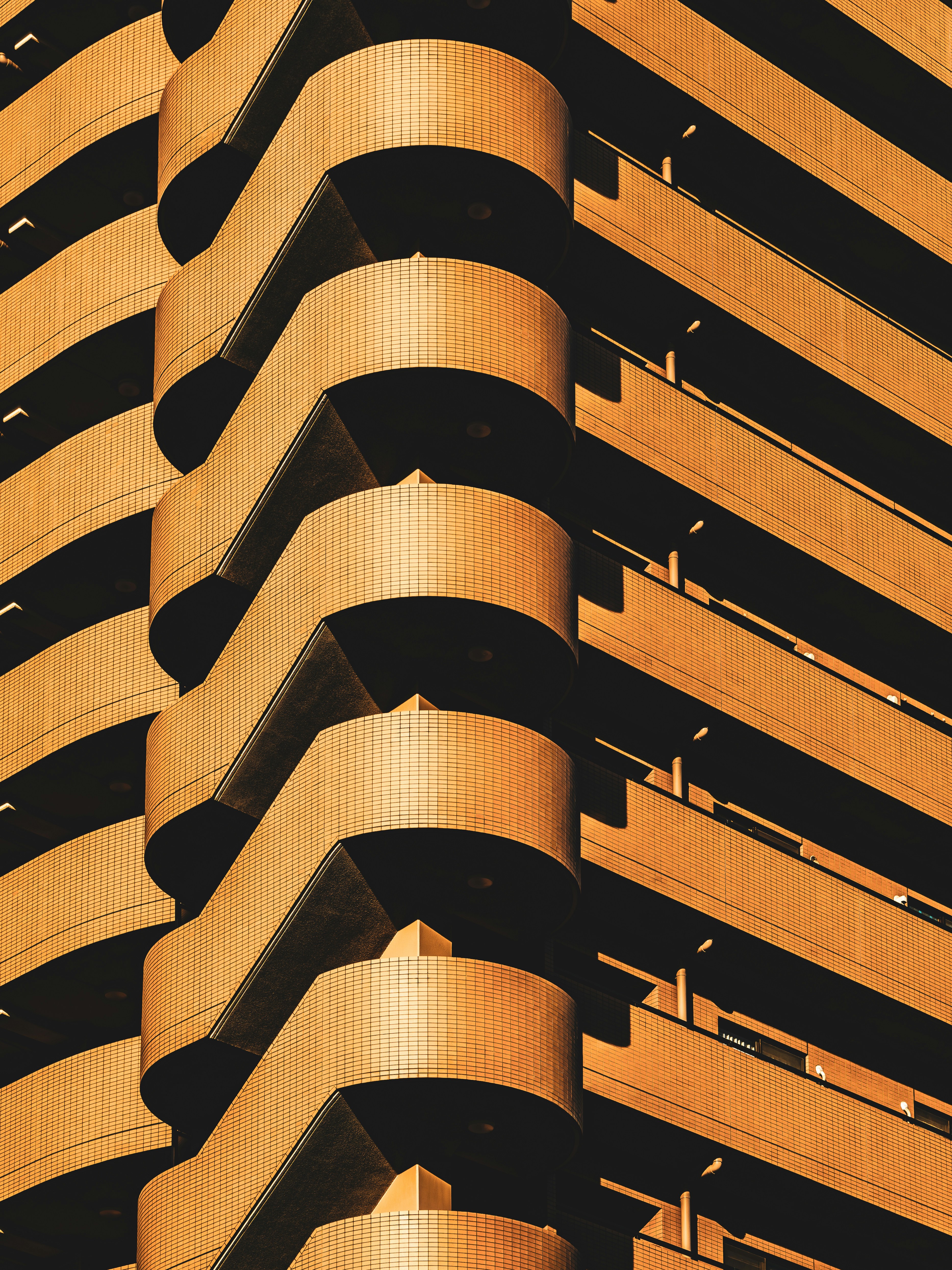 Orange building with curved balconies and shadows