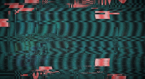 Glitchy television screen with red and teal static.