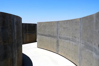 Curving concrete walls against a clear blue sky