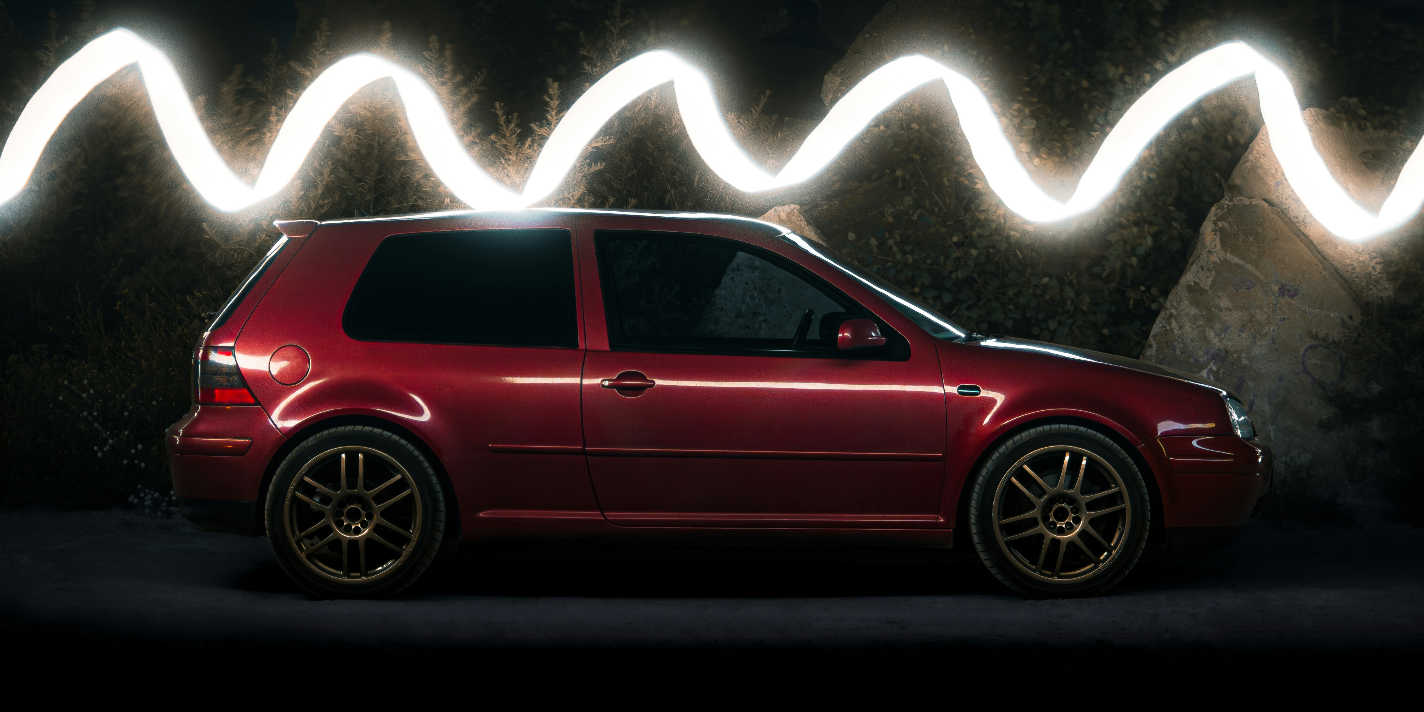 Red car with light streaks in dark background