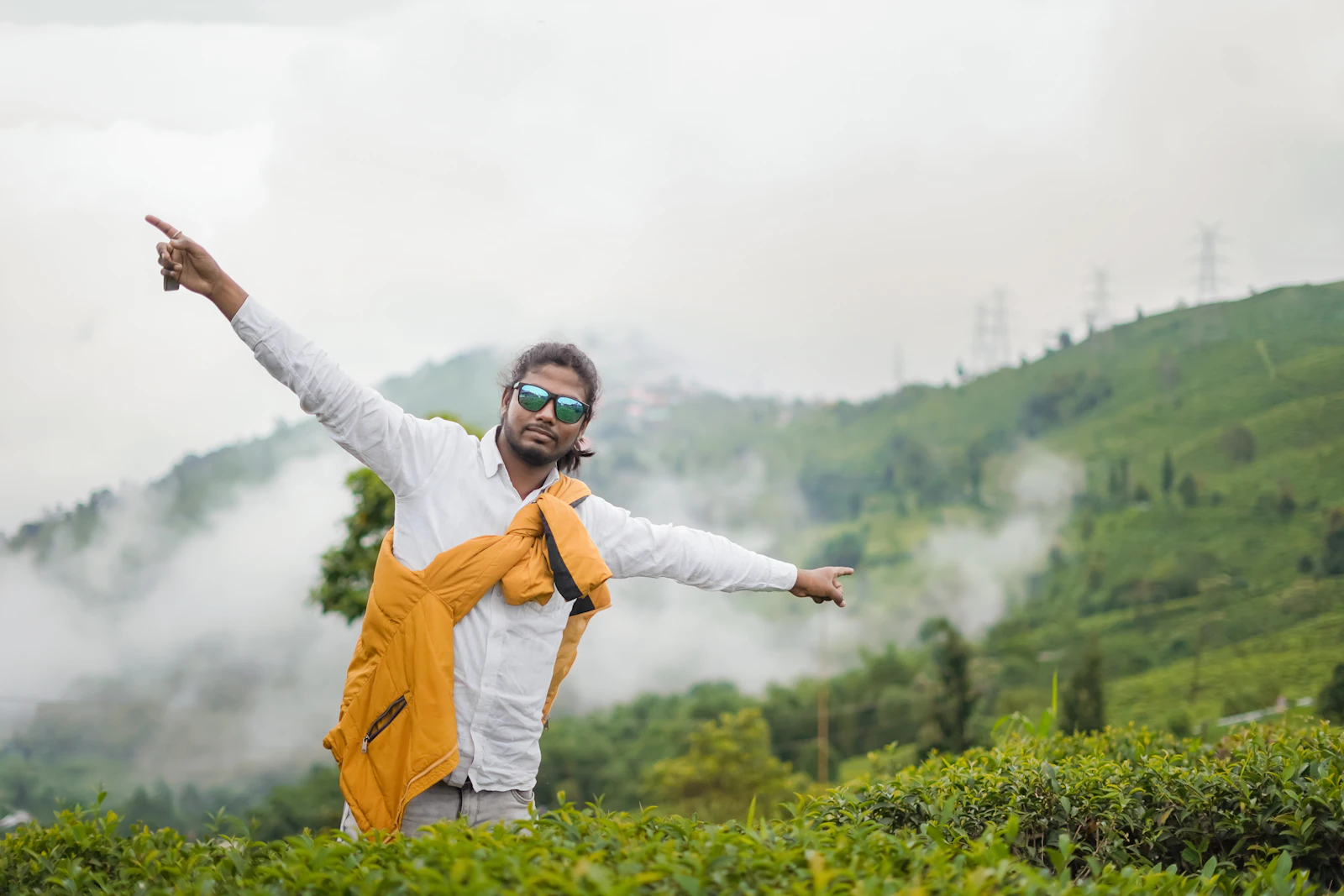 A man standing in a misty green tea plantation