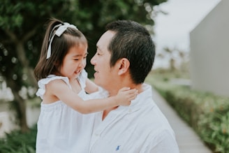 Father holds his young daughter outdoors