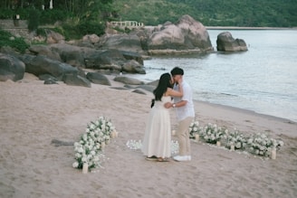 Couple kissing on a beach during a wedding ceremony.