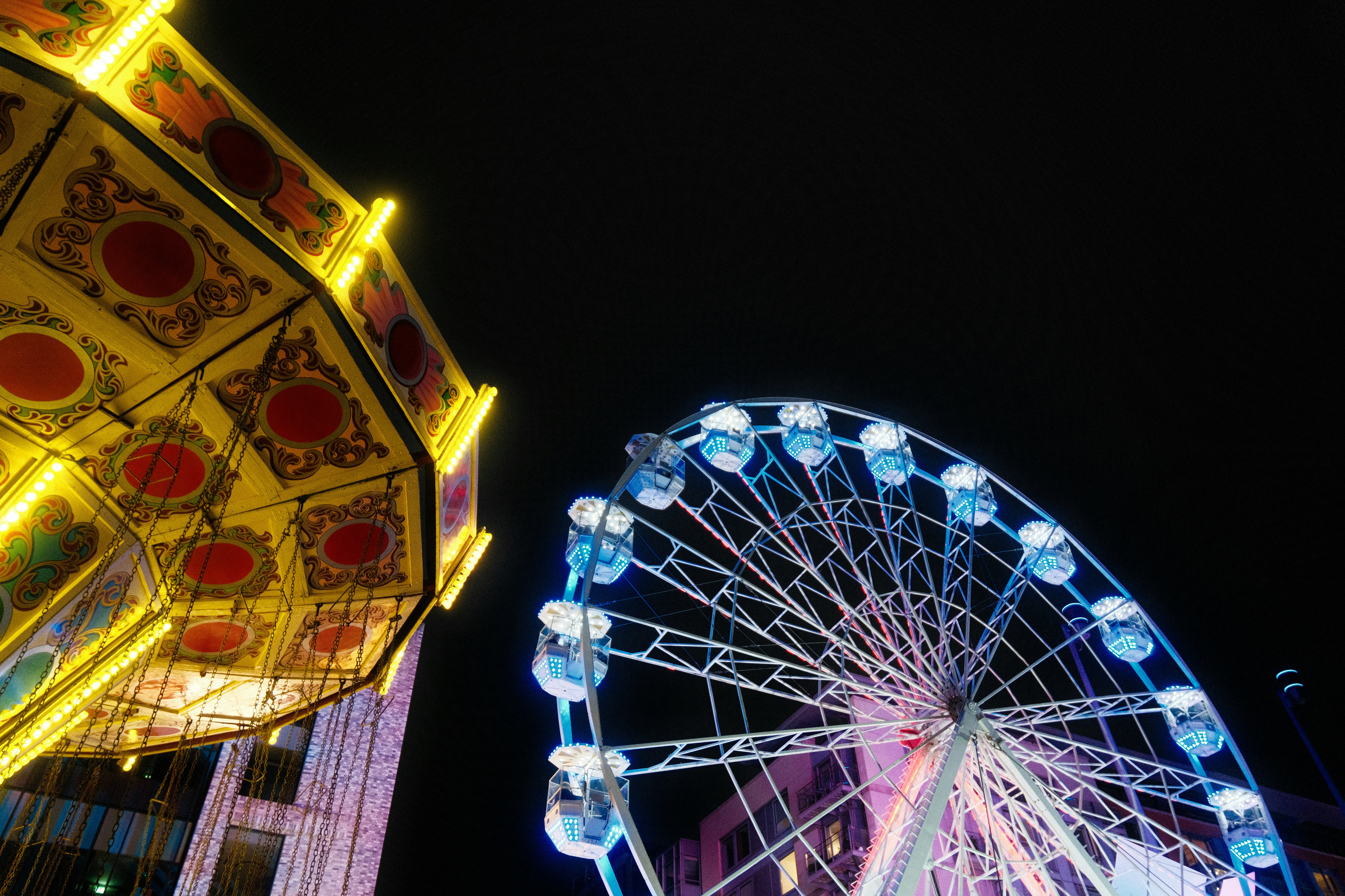 Bright ferris wheel and carousel at night