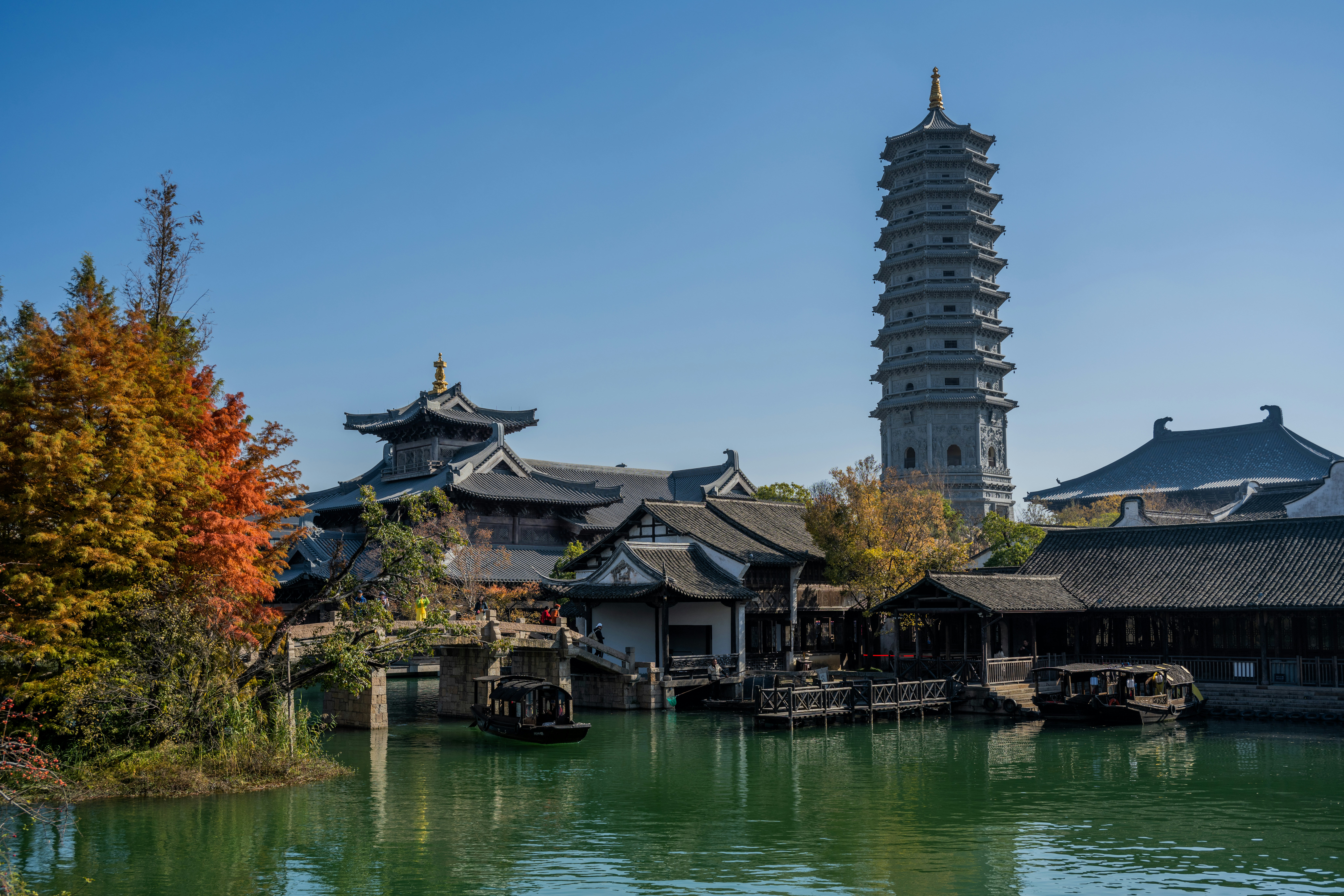 Traditional chinese architecture with a pagoda by a canal.