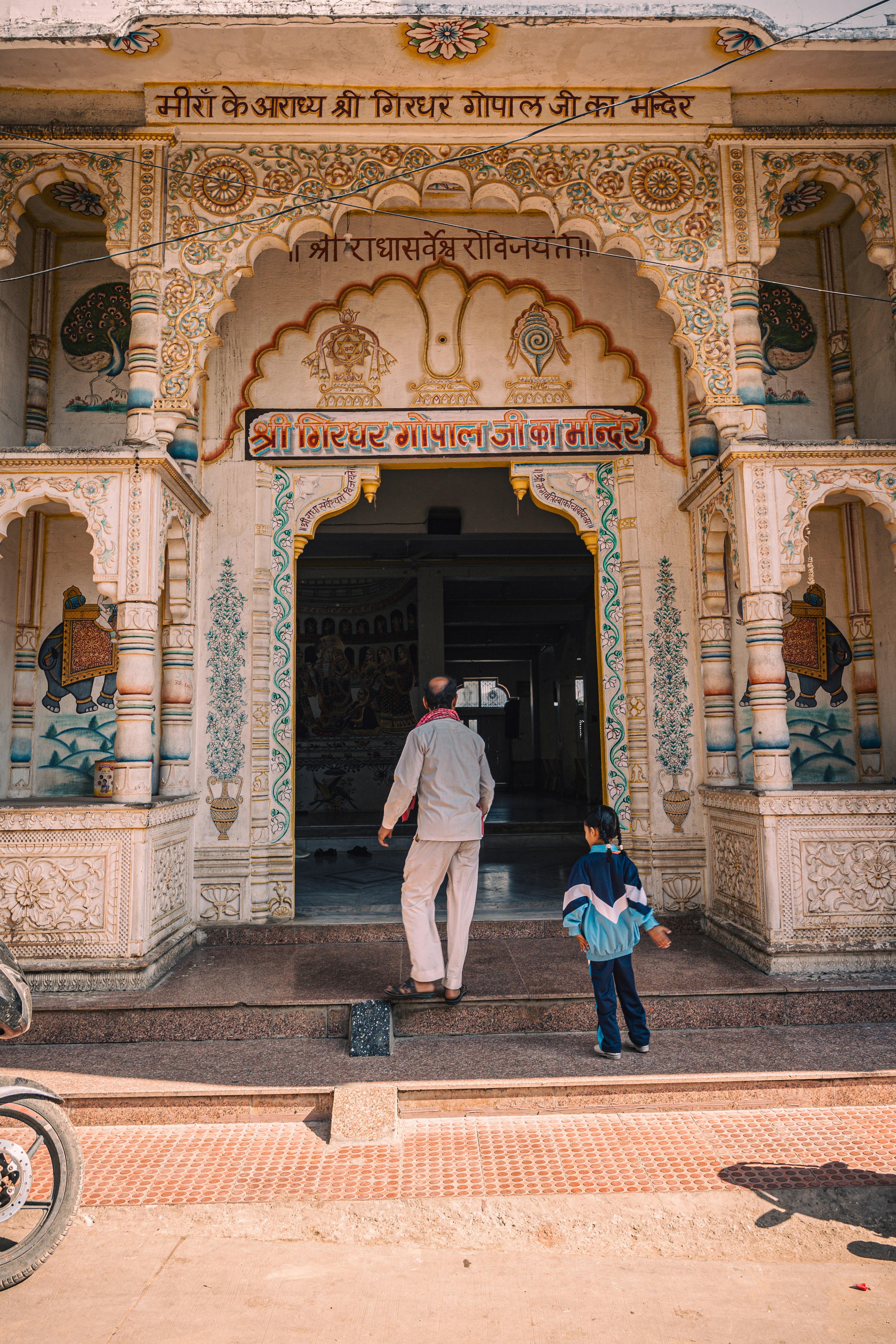 Man and child enter ornate temple entrance