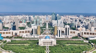 Modern cityscape with grand architecture and green spaces.