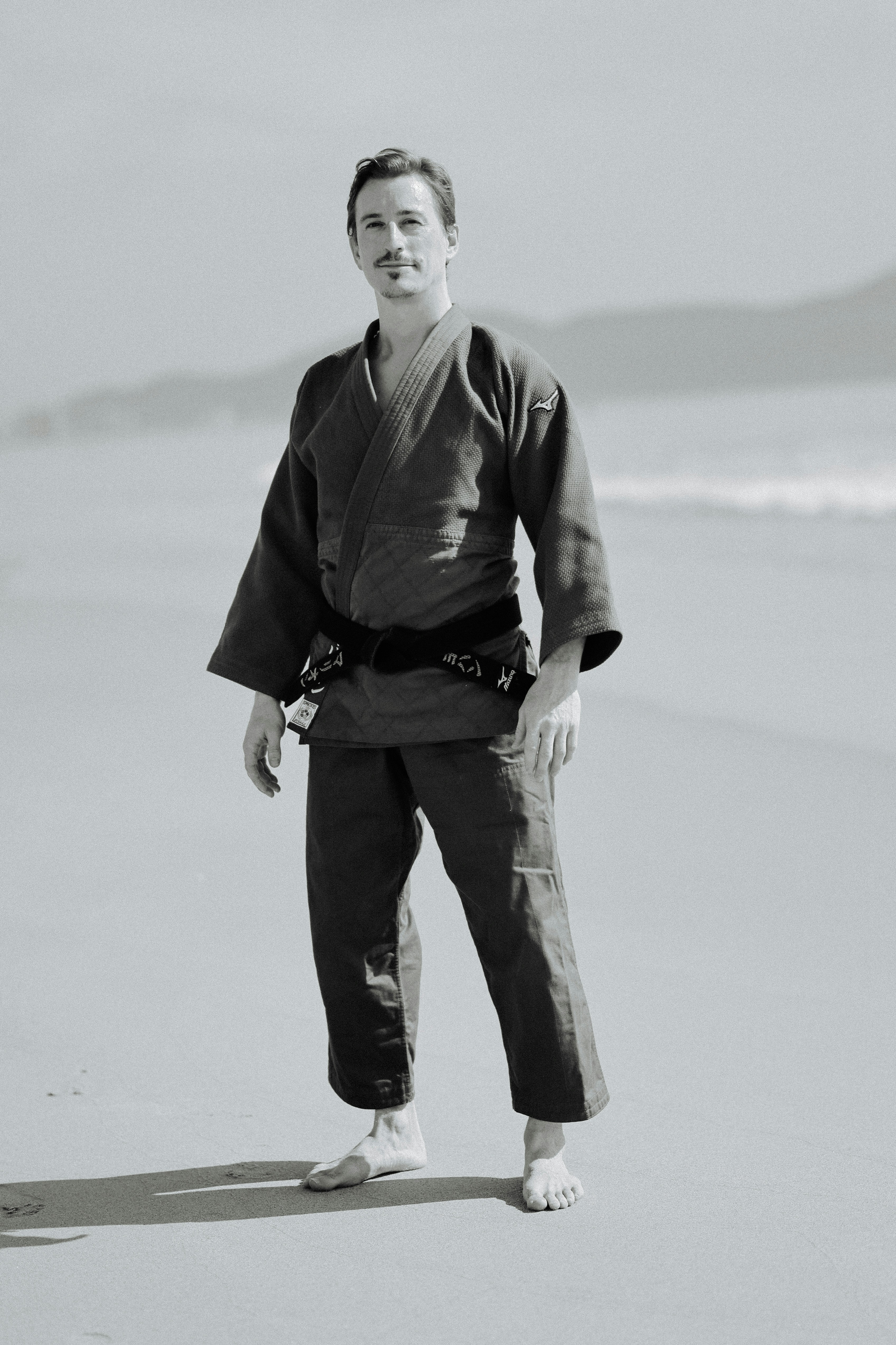 Man in martial arts uniform on a sandy beach