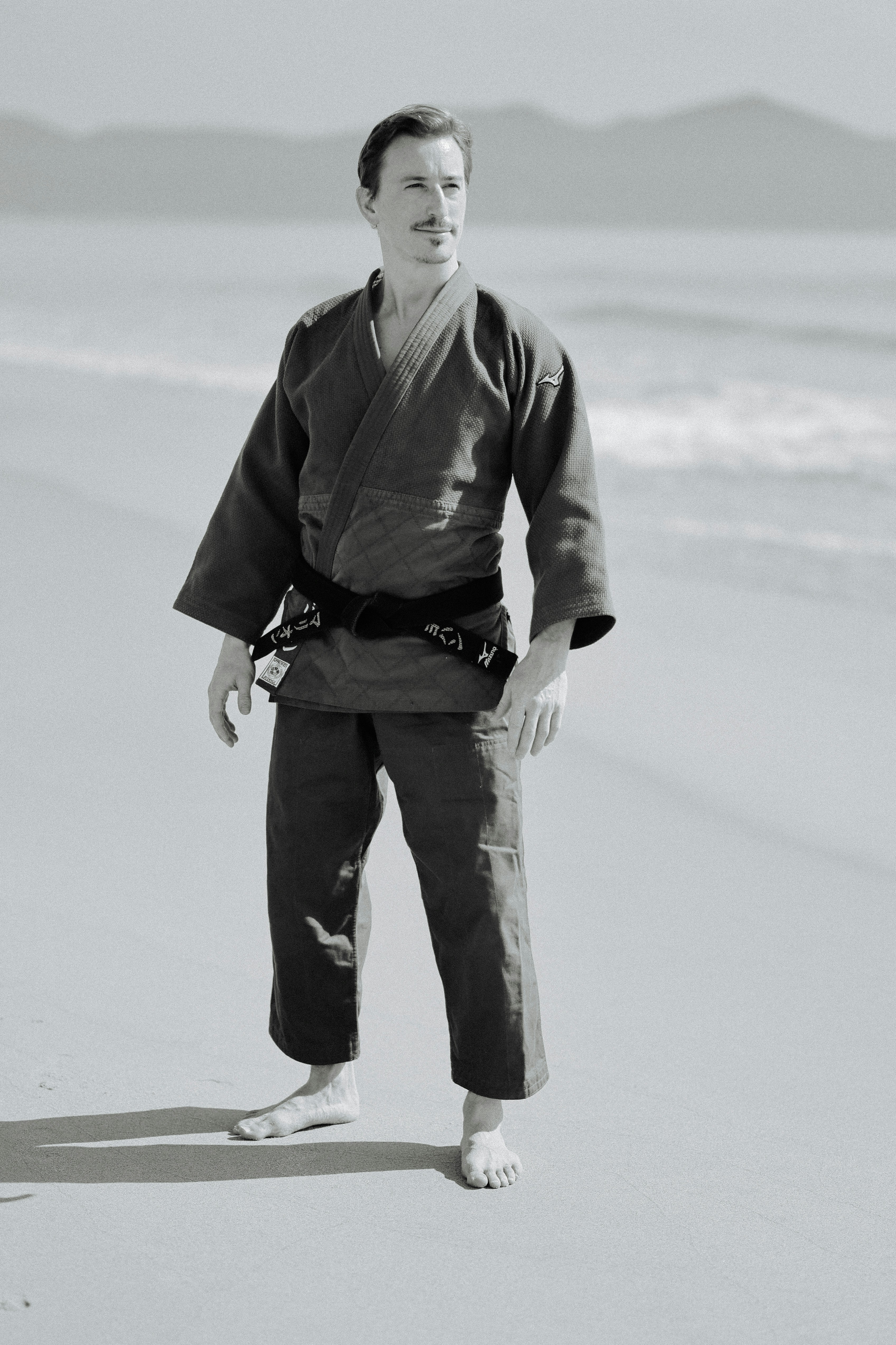Man in martial arts uniform on a beach