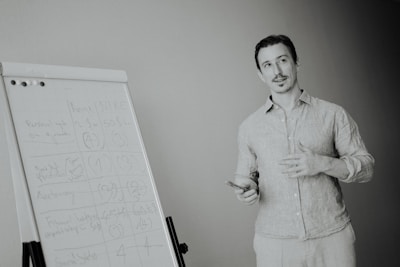 Man presenting at a whiteboard in a meeting.