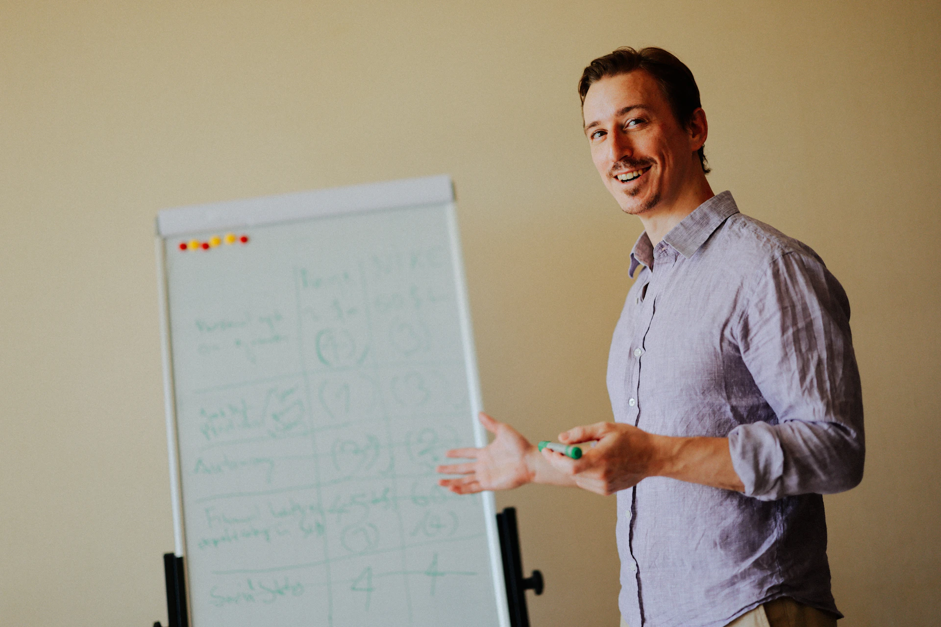 Man presenting at a whiteboard with marker.