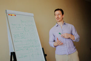 Man presenting at a whiteboard with notes.