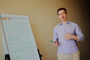 Man presenting near a whiteboard with notes.