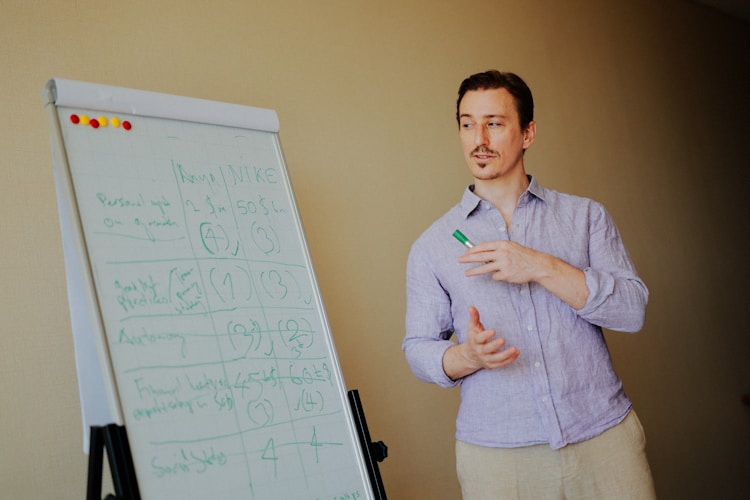 A man standing near a whiteboard in an office setting, representing the careful planning process required for precious metals estate documentation