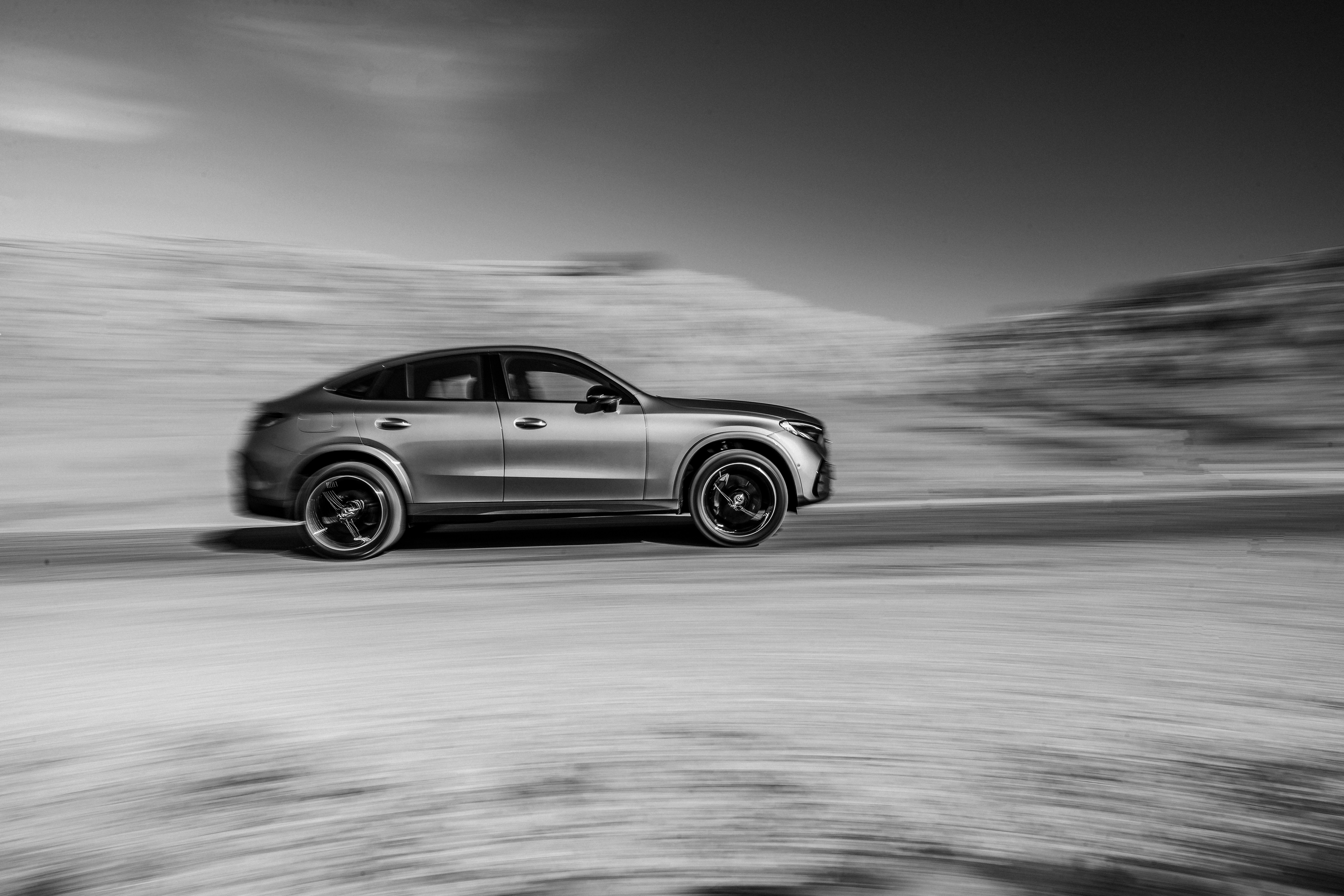 Silver coupe driving on a blurred road