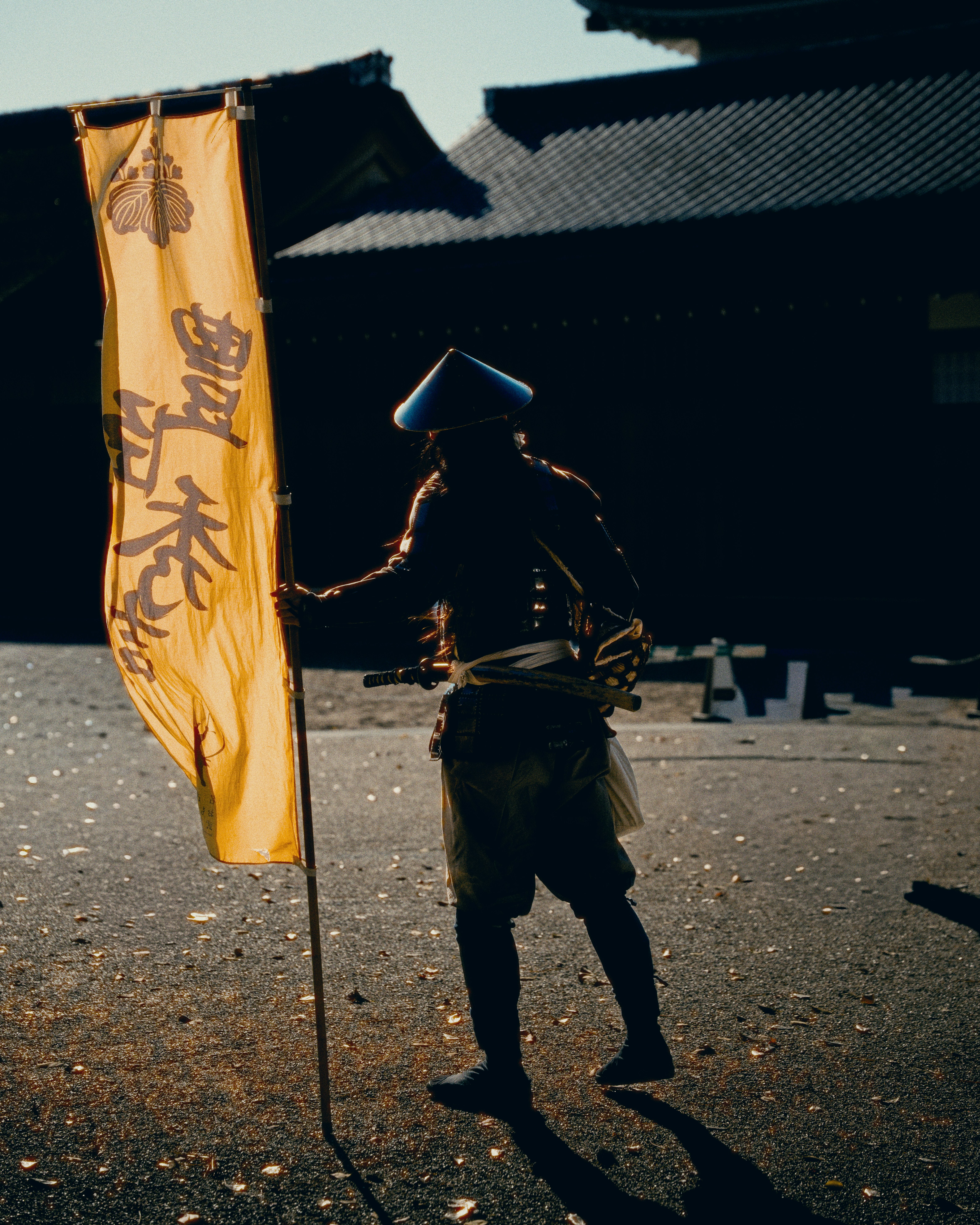 일본어 글자가 적힌 노란색 현수막을 든 사무라이.