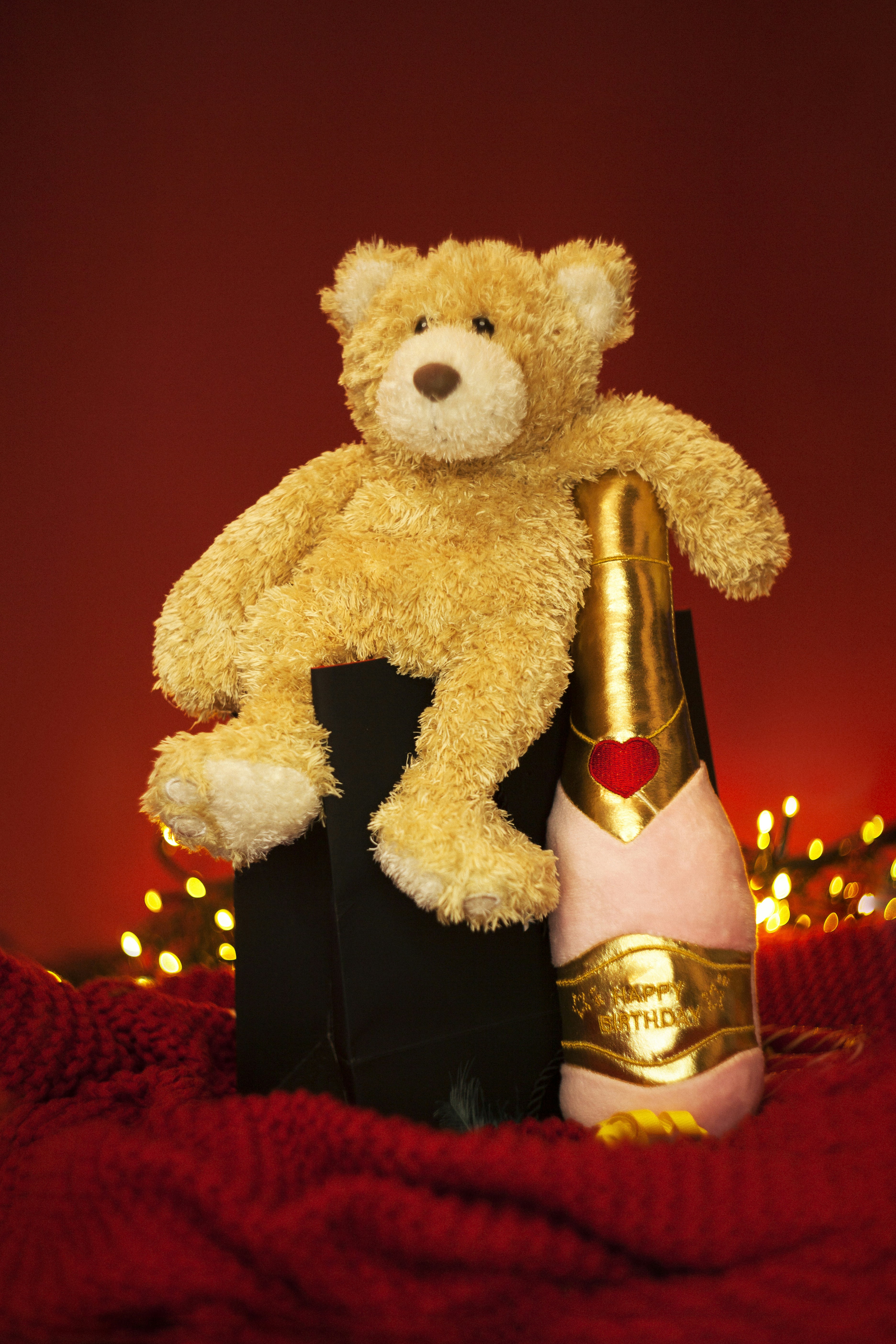Teddy bear with champagne bottle and festive lights