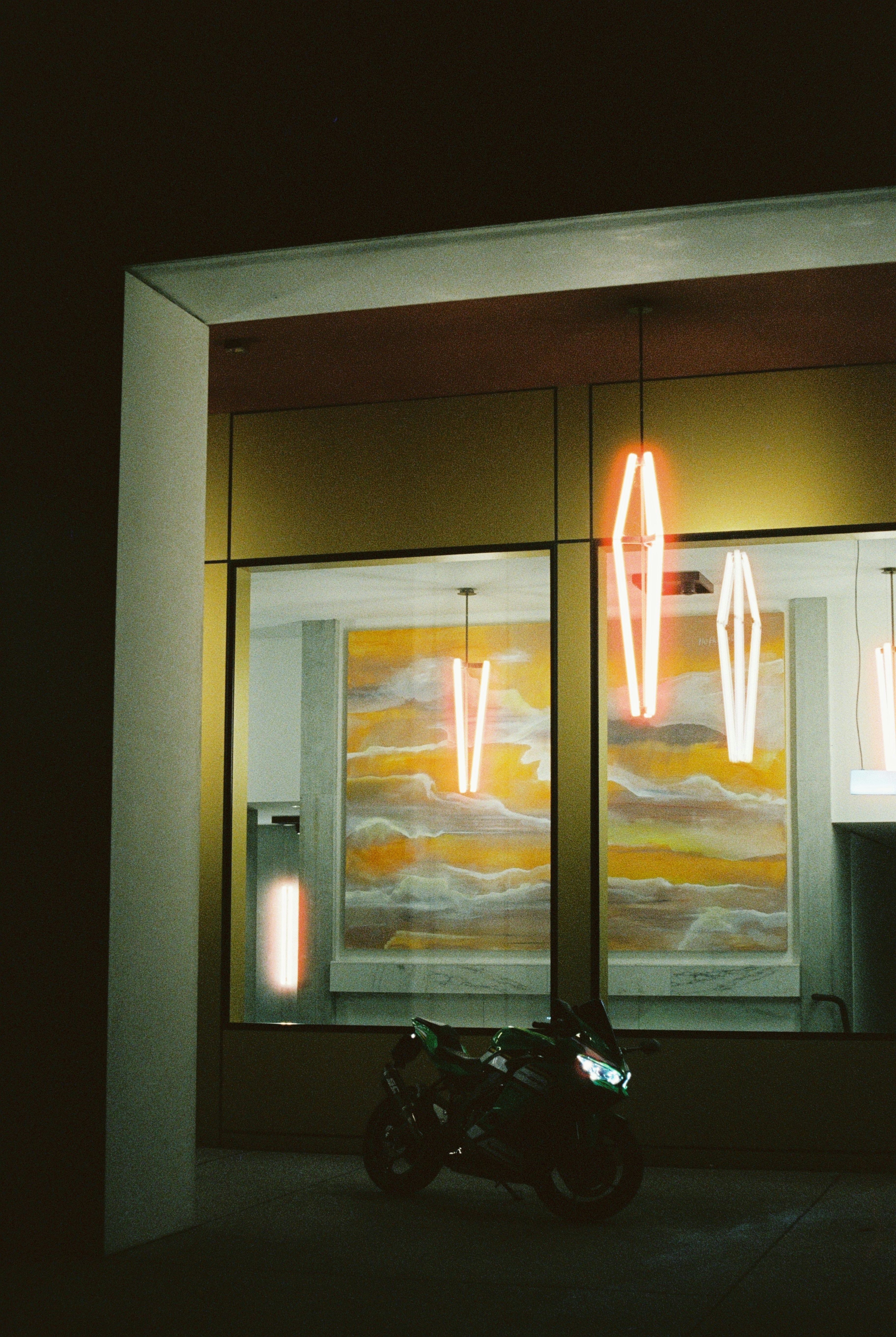 Motorcycle parked outside building with neon lights