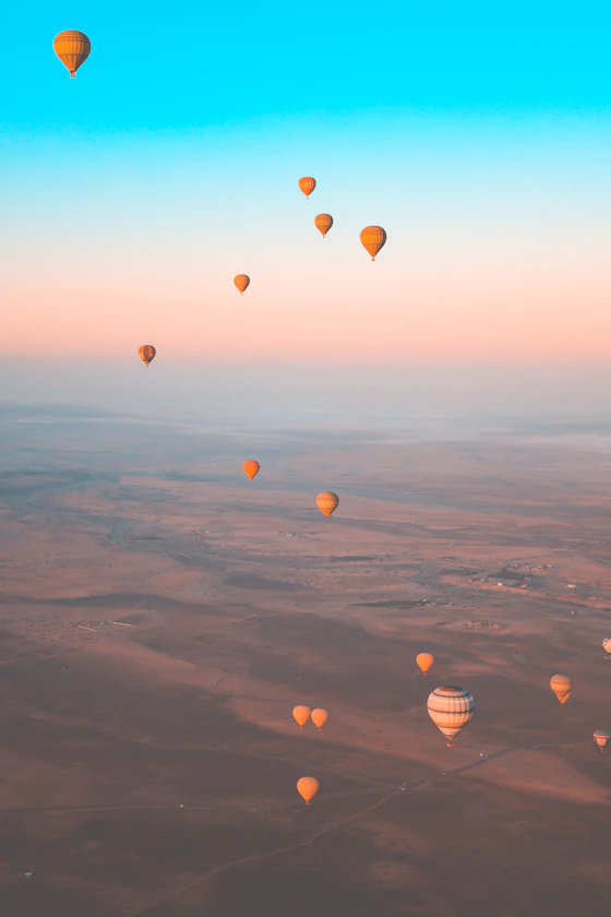 Globos elevándose sobre el desierto al amanecer