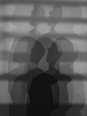 Multiple overlapping silhouettes of a person's head and shoulders.