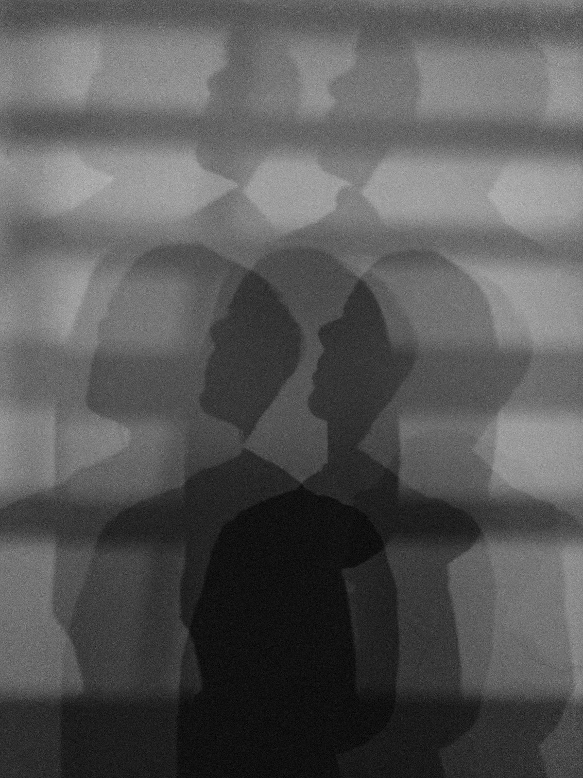 Multiple overlapping silhouettes of a person, representing the transformation of identity