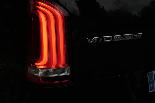 Close-up of a car's illuminated taillight and badge