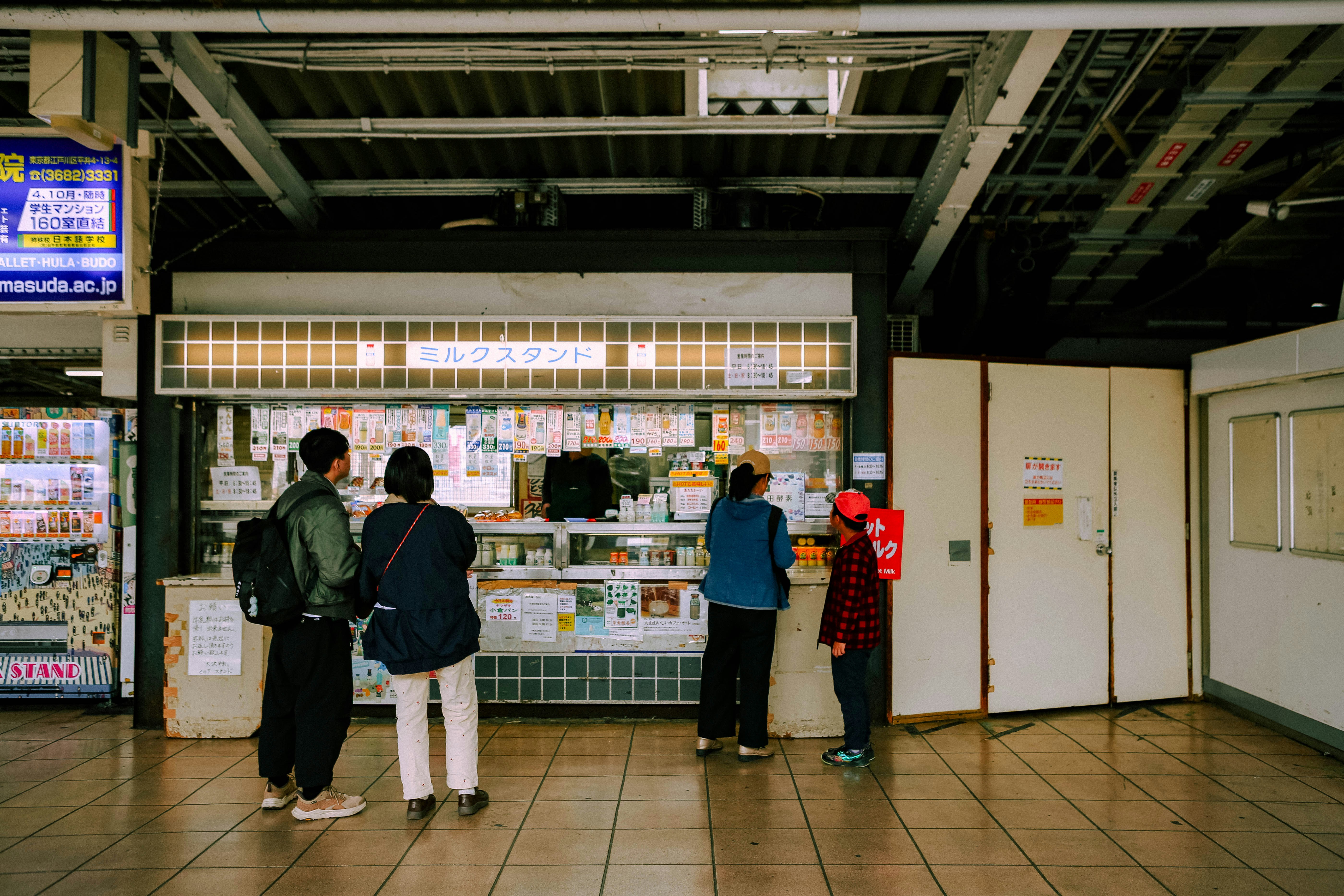Tax-Free counter in a Japanese department store, with signs in Japanese and English, and a staff member assisting a customer with a passport