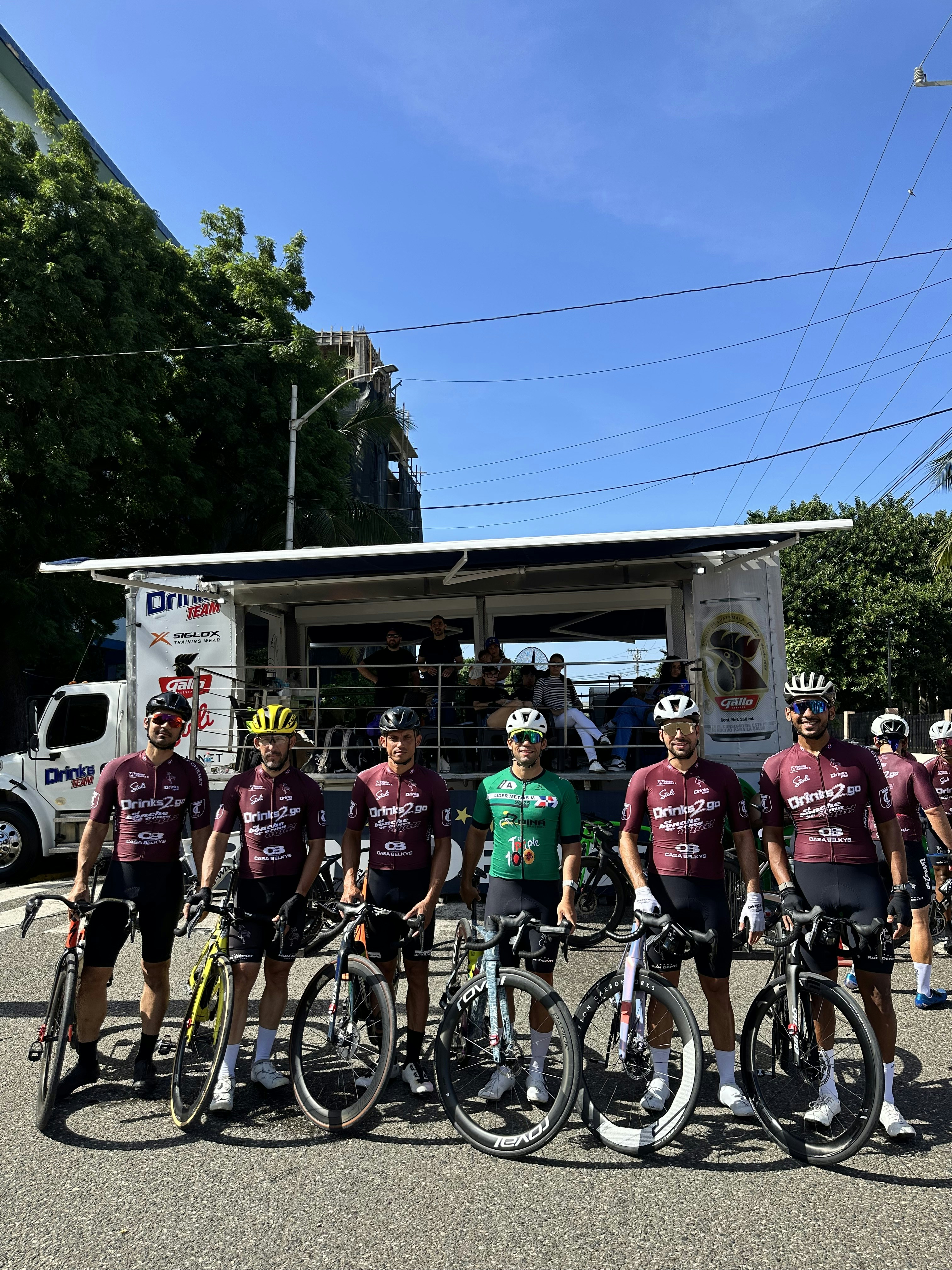 Cyclists in matching jerseys pose with bicycles