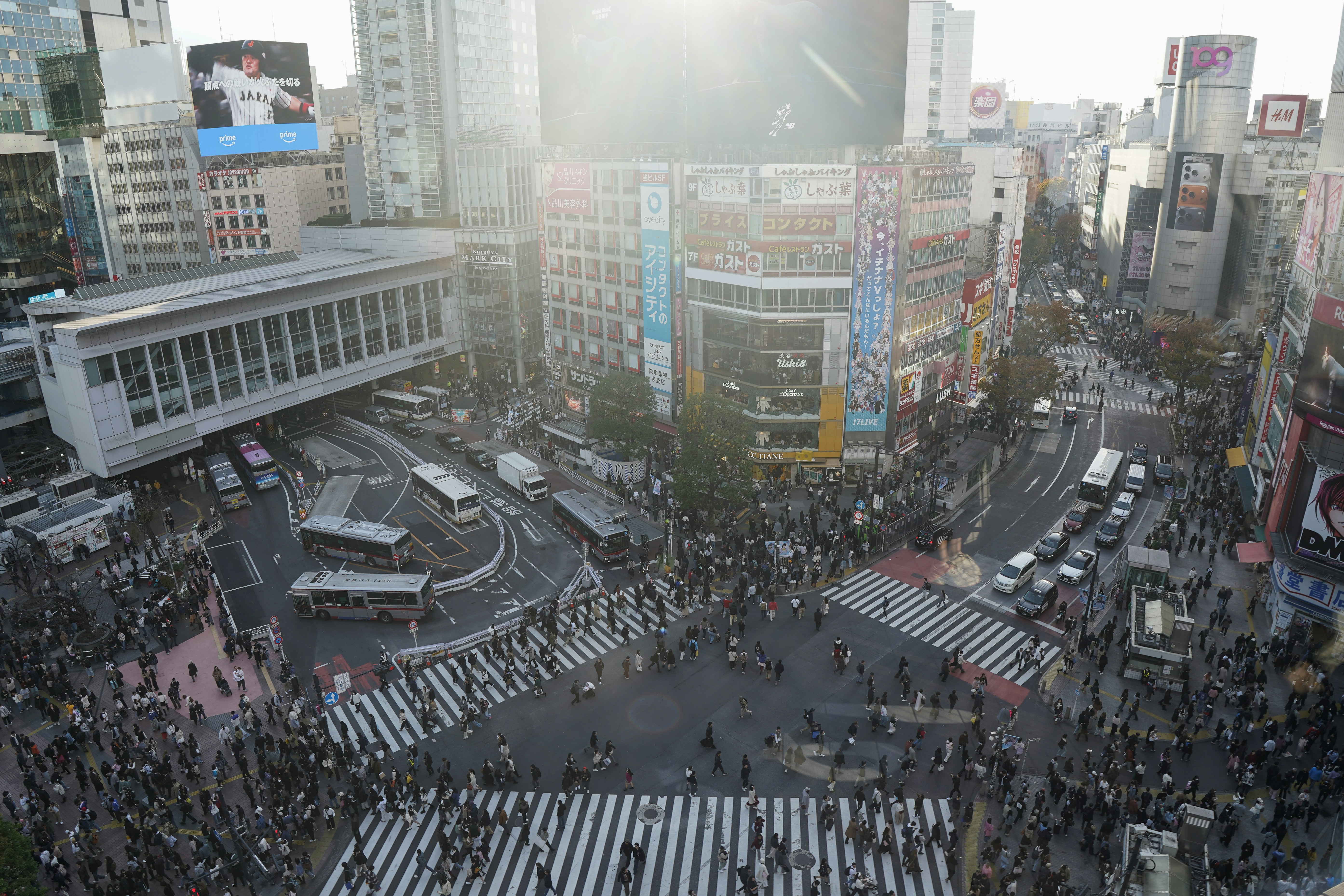 Crowded shibuya crossing with traffic and pedestrians