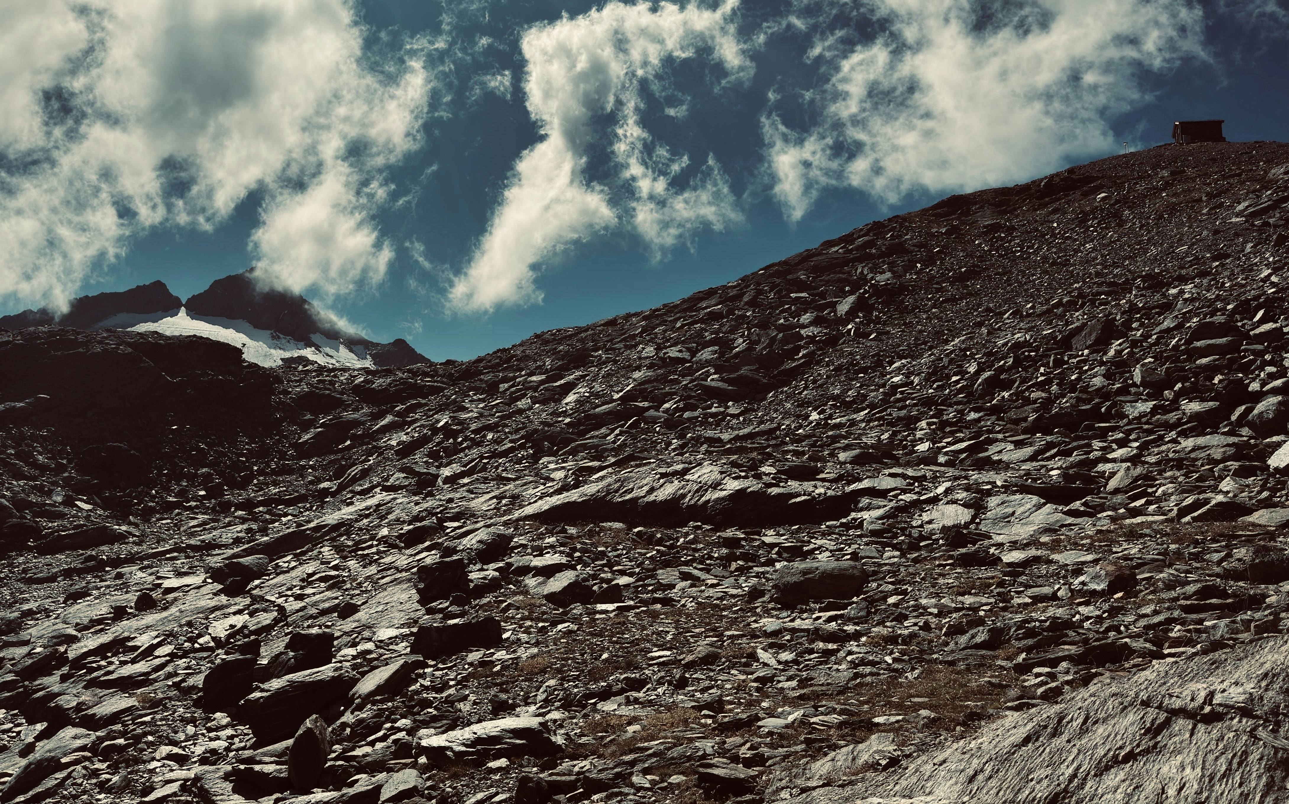 Rocky mountain slope with a small building on top