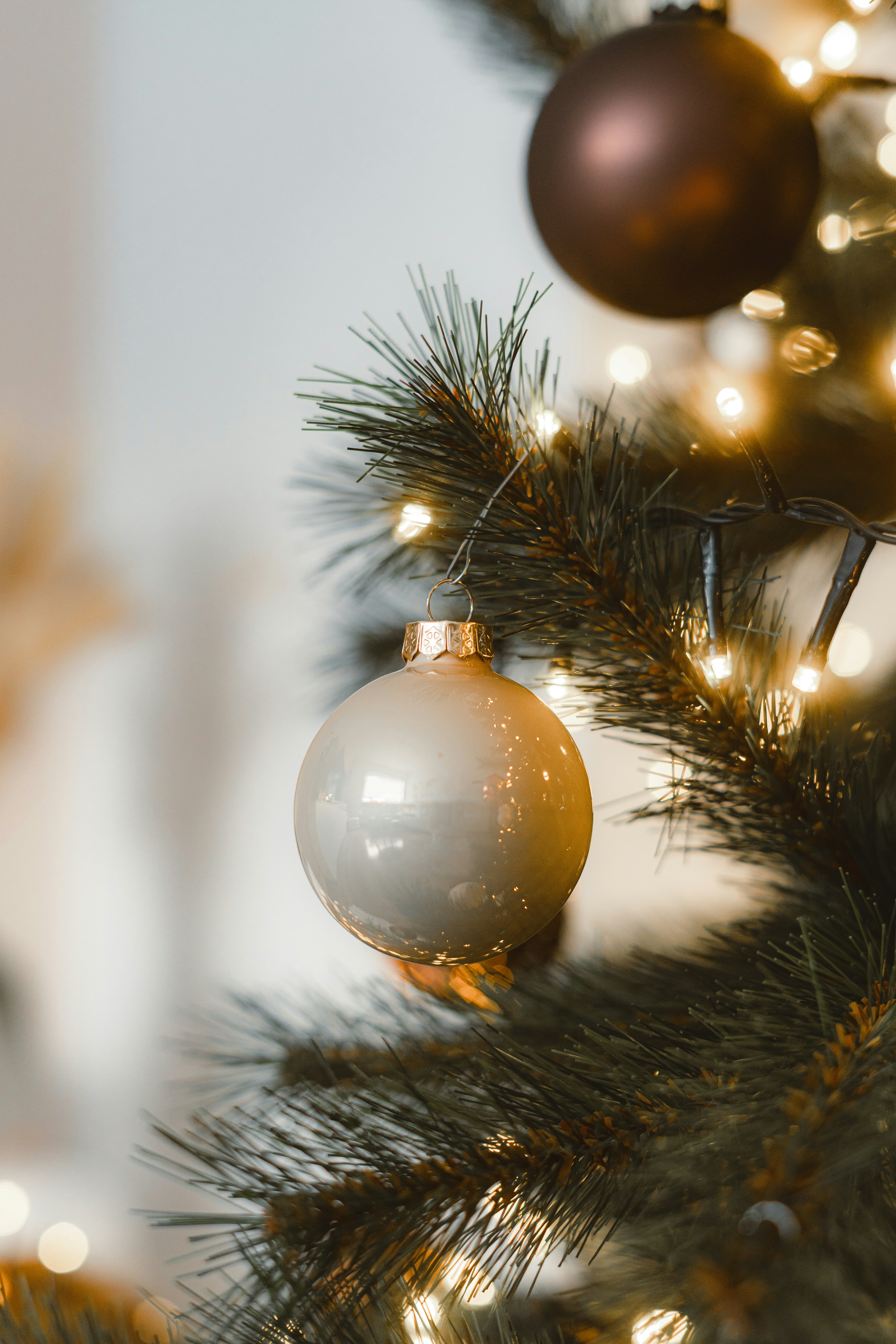 Nahaufnahme eines Weihnachtsbaums mit Ornamenten und Lichtern.