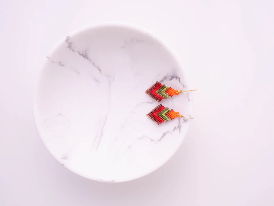 Colorful handmade chevron earrings on a marble dish