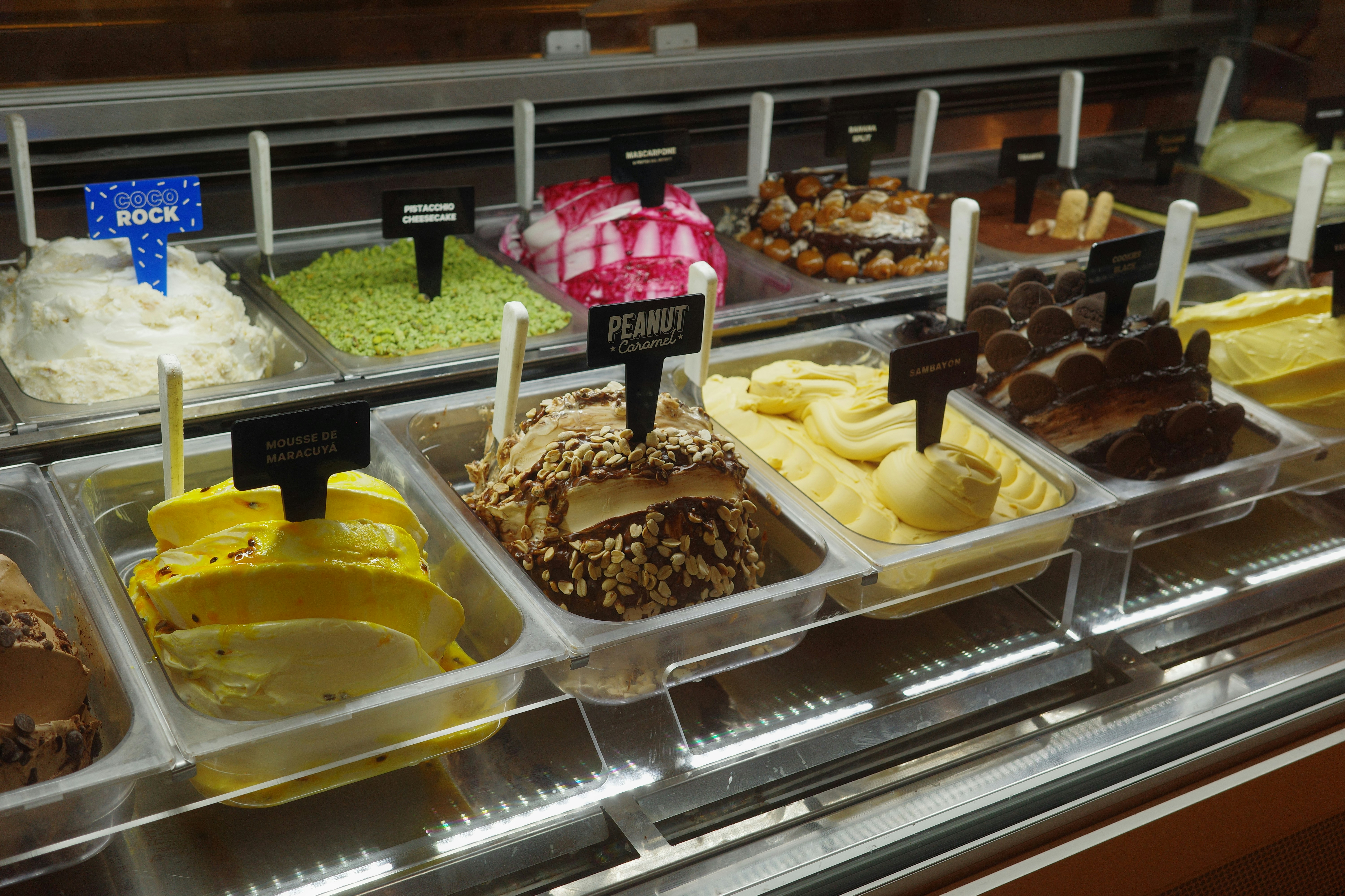 Assortment of colorful gelato flavors in display case.