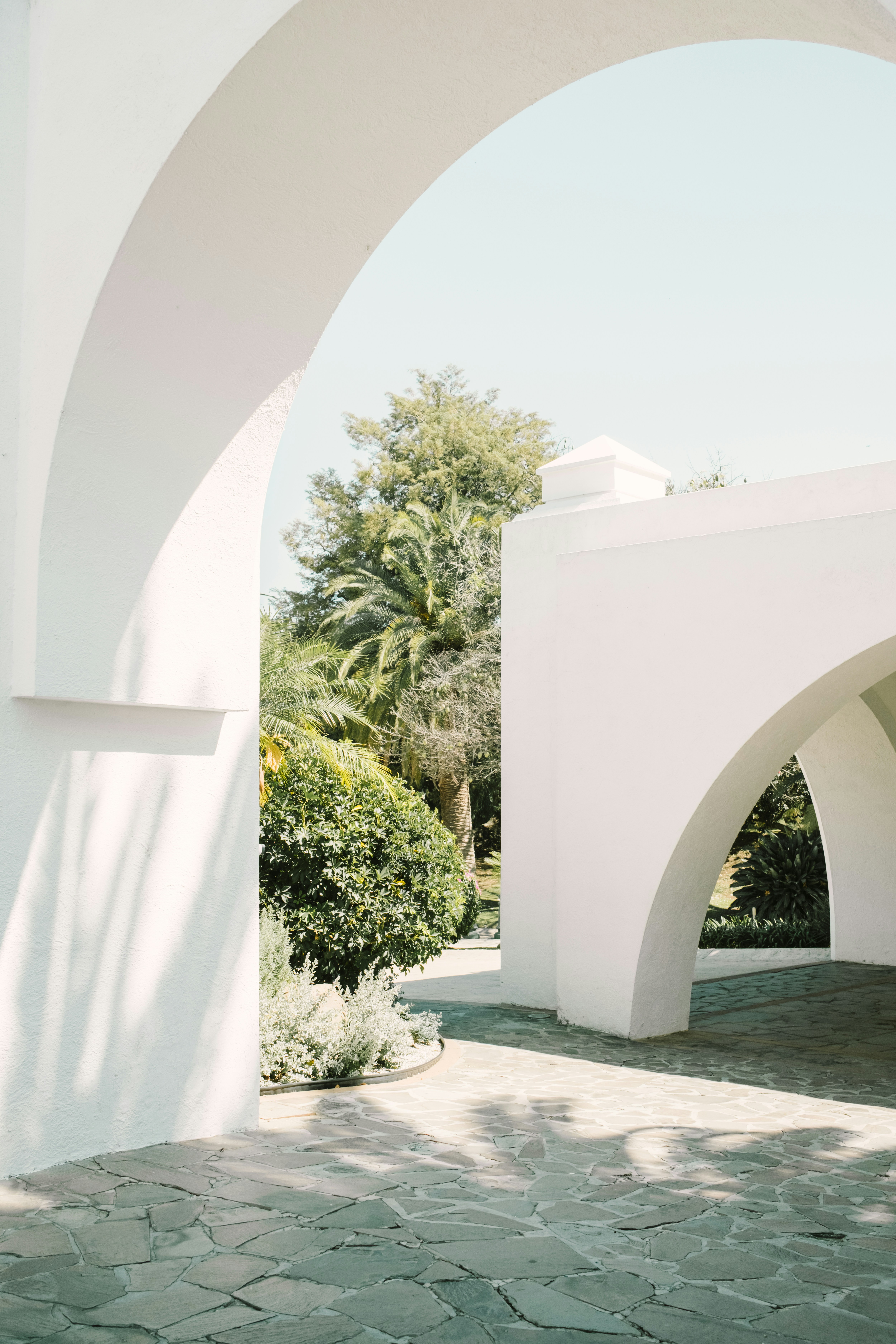 White arched walkways with lush green garden